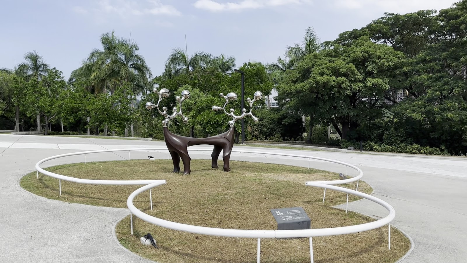 高雄市立美術館戶外廣場，麋鹿造型金屬雕塑，頭頂銀色球狀裝飾，白色圓形圍欄