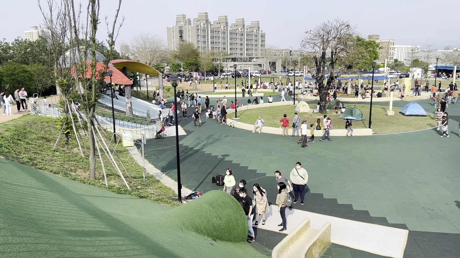 竹南獅山親子公園鳥瞰，寬闊的場地上許多家庭帶孩子玩耍