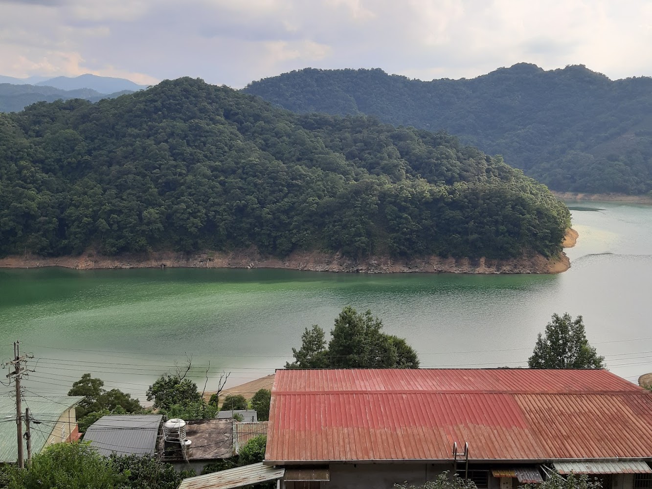 湖畔山林與建築屋頂同框景色