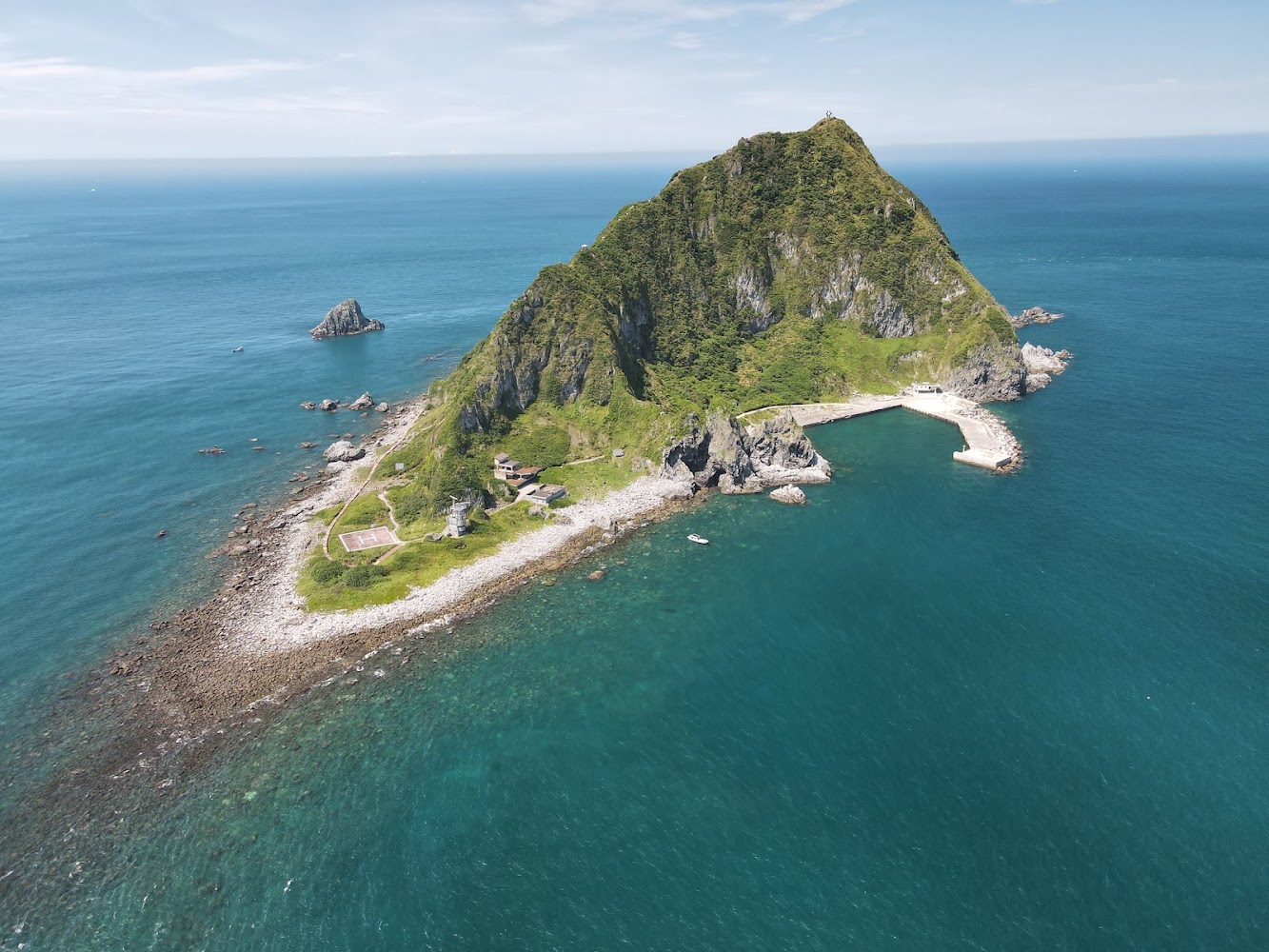 位於海上的基隆嶼全景,可見碼頭、建築與綠意山體