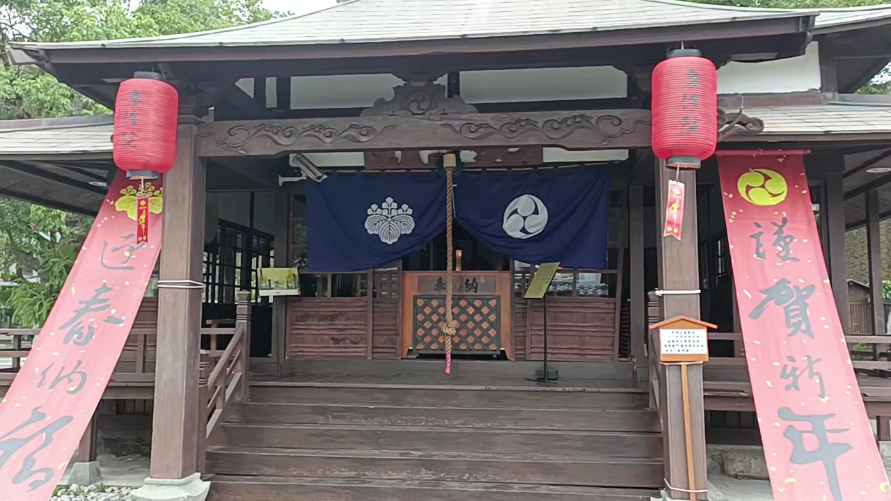 吉安慶修院本堂正面節慶裝飾，紅燈籠高掛，粉色春聯，藍色家紋布幕