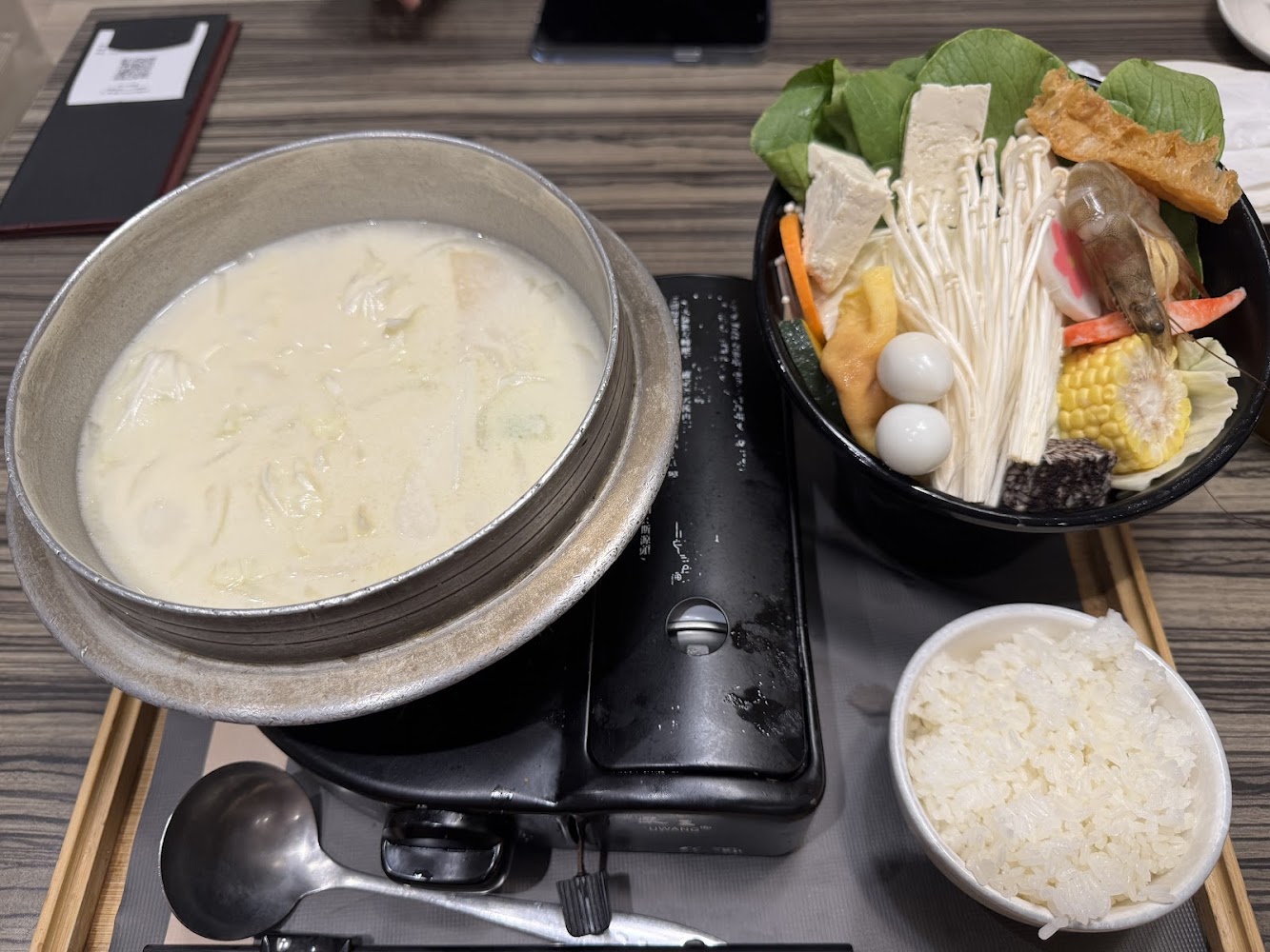 火鍋套餐，包括奶白色湯底、豐富配料與白飯