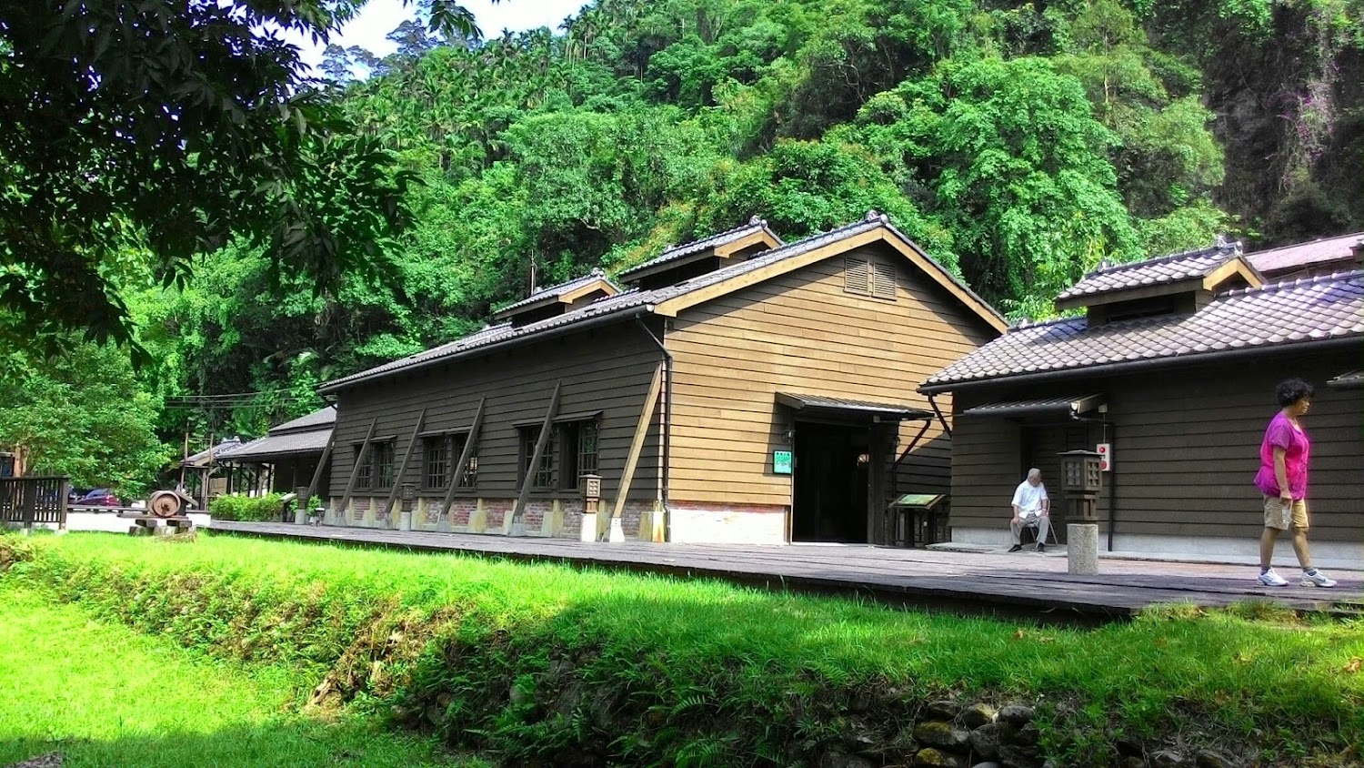 日式木造建築前景有草地與木棧道
