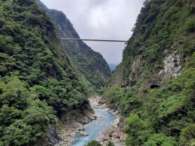 燕子口峽谷全景，吊橋橫跨山谷深處，藍色立霧溪流淌其間