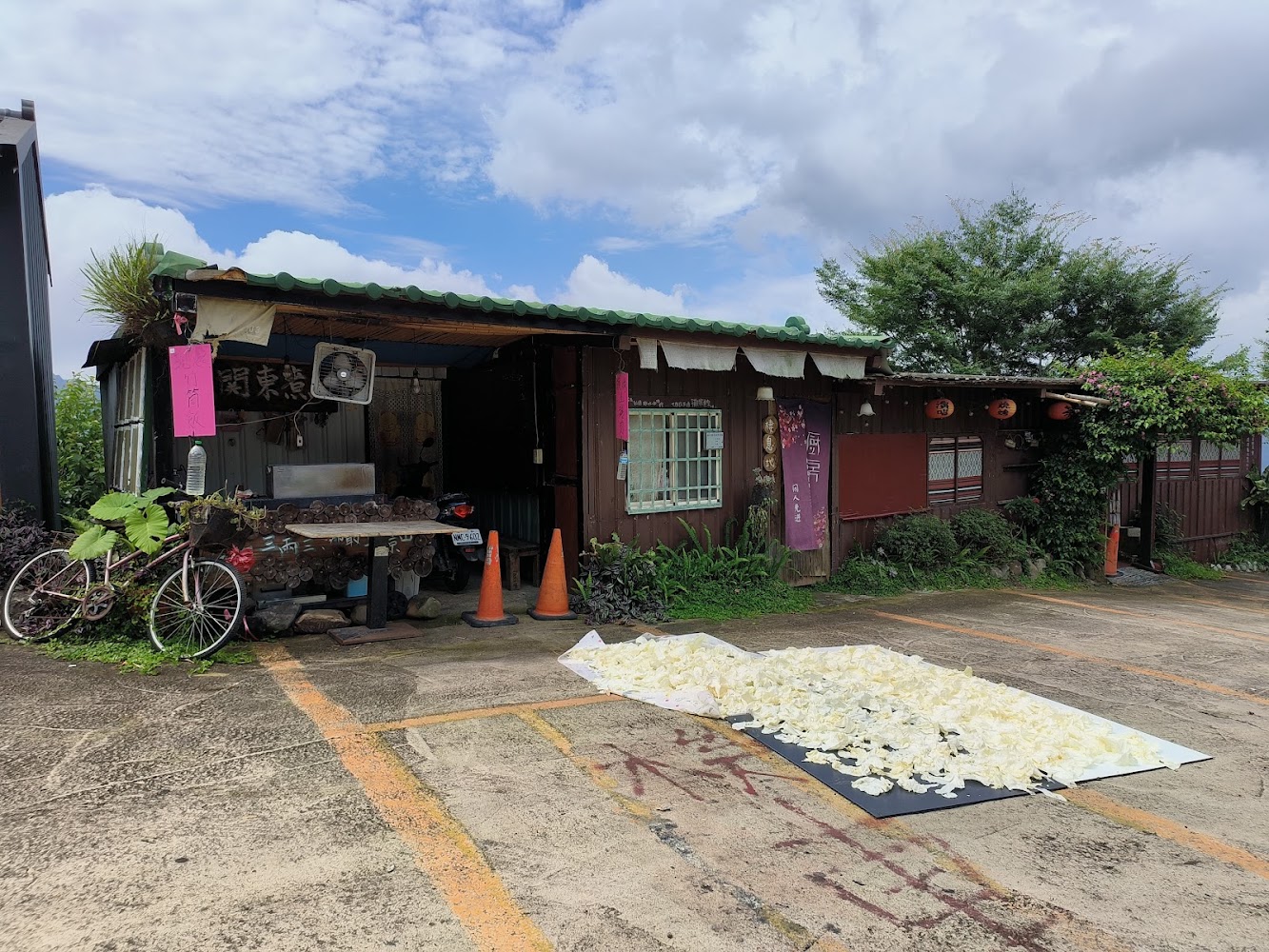 鄉村小屋前有腳踏車與自然曬物的山居景象