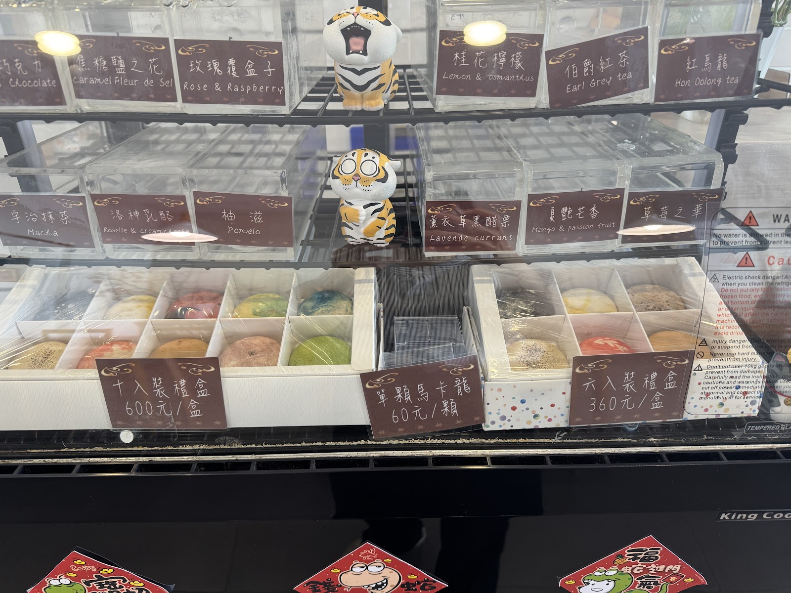 雨田家馬卡龍展示冰櫃含價格標示，老虎公仔裝飾