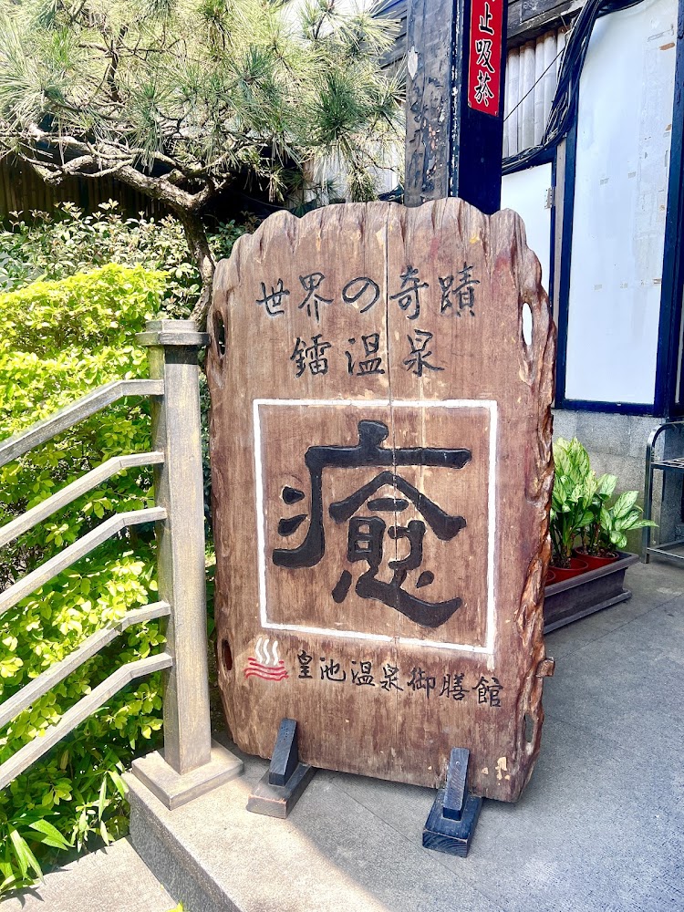 木製溫泉療癒招牌與綠樹背景