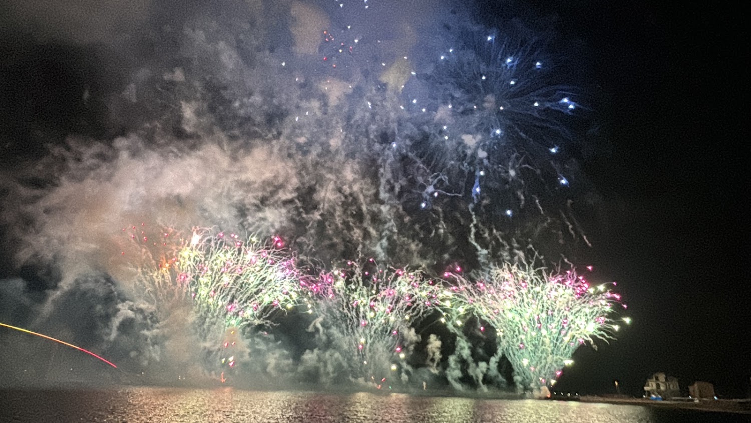 夜晚水面上綻放的絢麗煙火