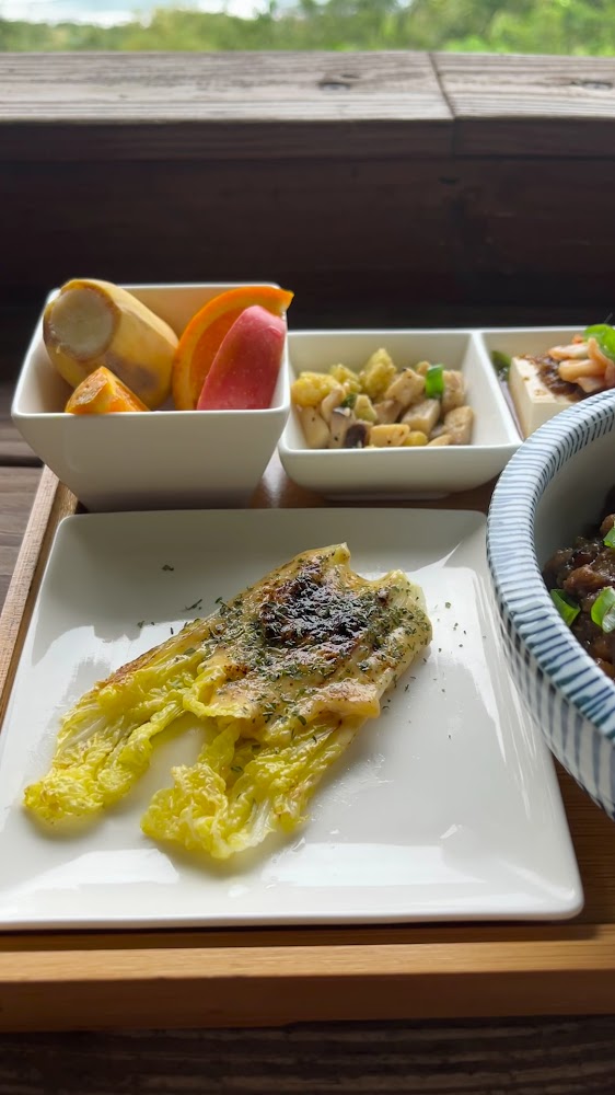 這張圖片是一套餐點，有焗烤白菜、切片水果、炒菇蔬菜、豆腐和牛肉飯，看起來健康豐富且擺盤精緻。