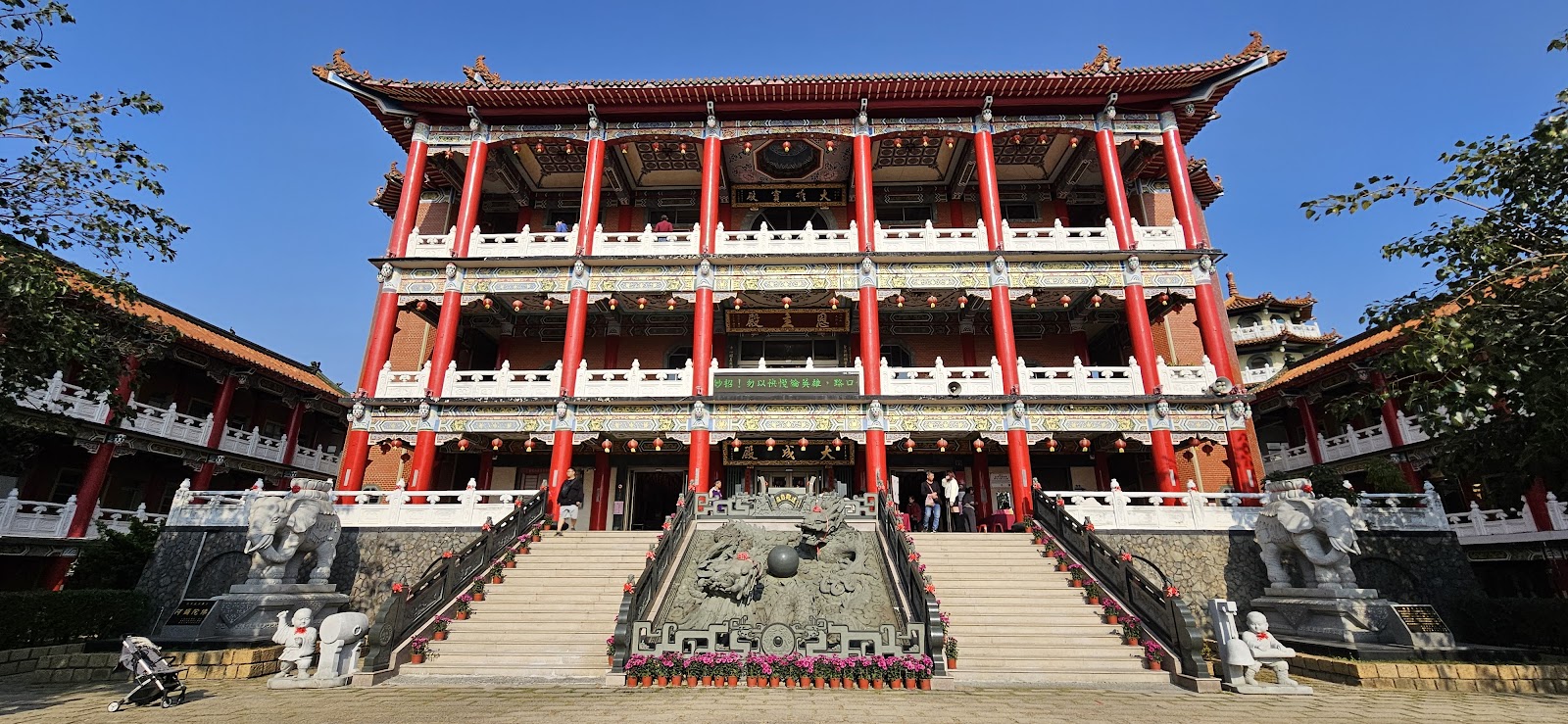 八卦山開化寺廟宇正面,三層紅柱建築,石象守門,藍天背景