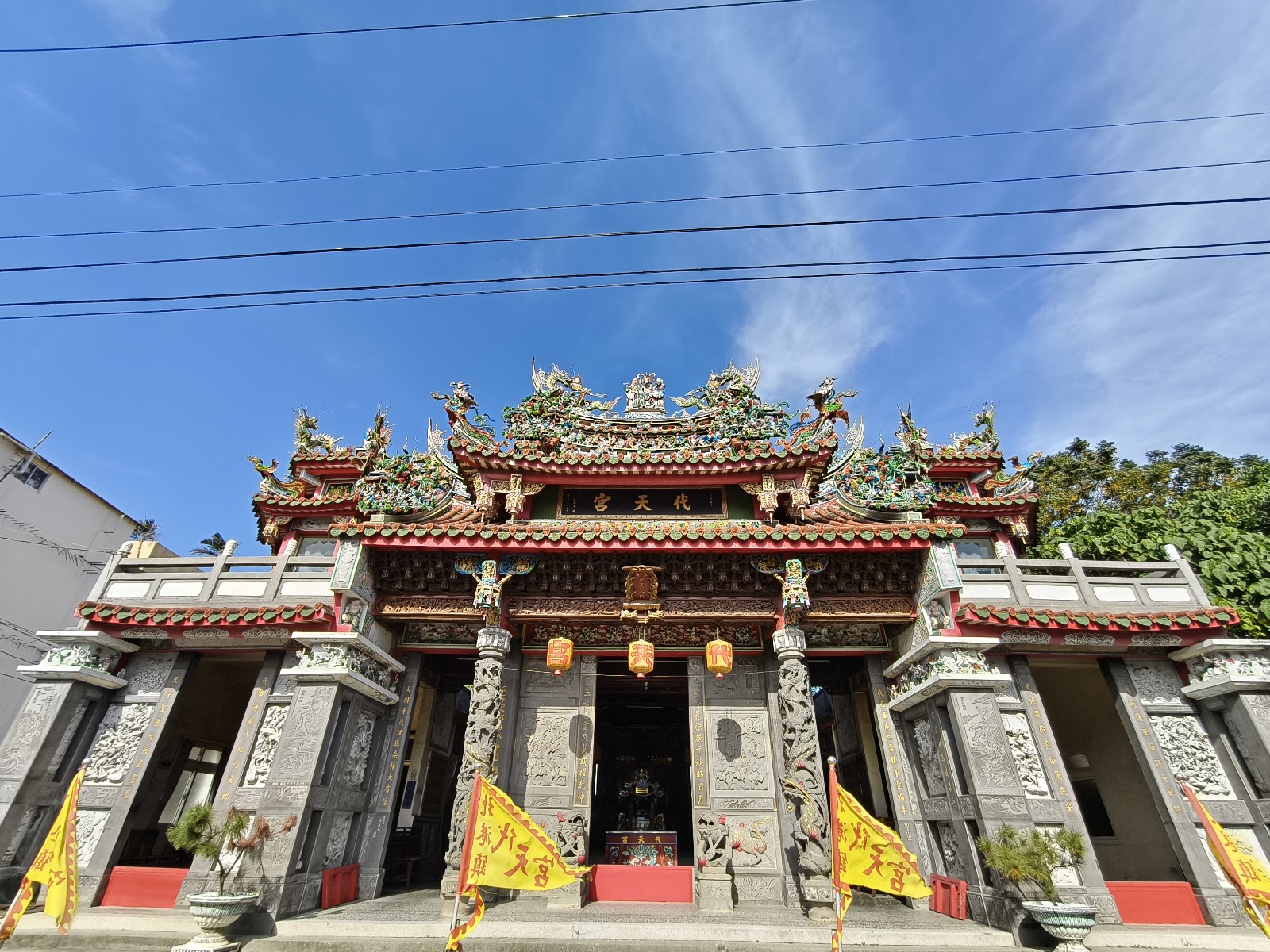 北港代天宮外觀石雕龍柱灰石紅邊廟門黃旗