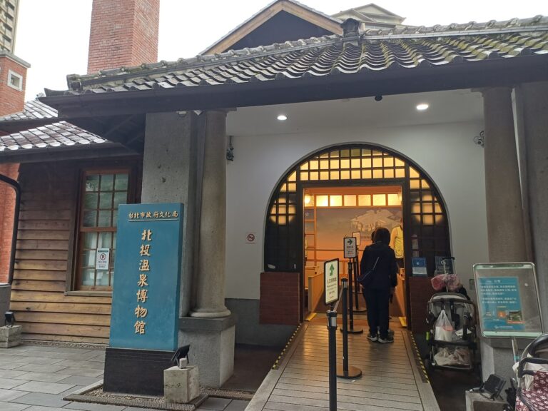 北投溫泉博物館入口藍色招牌，日式歷史建築外觀