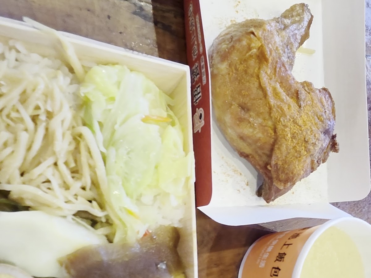 悟饕池上飯包打開後的內容，白飯、香腸、滷肉、蔬菜豐盛擺放，旁邊附有一杯清湯