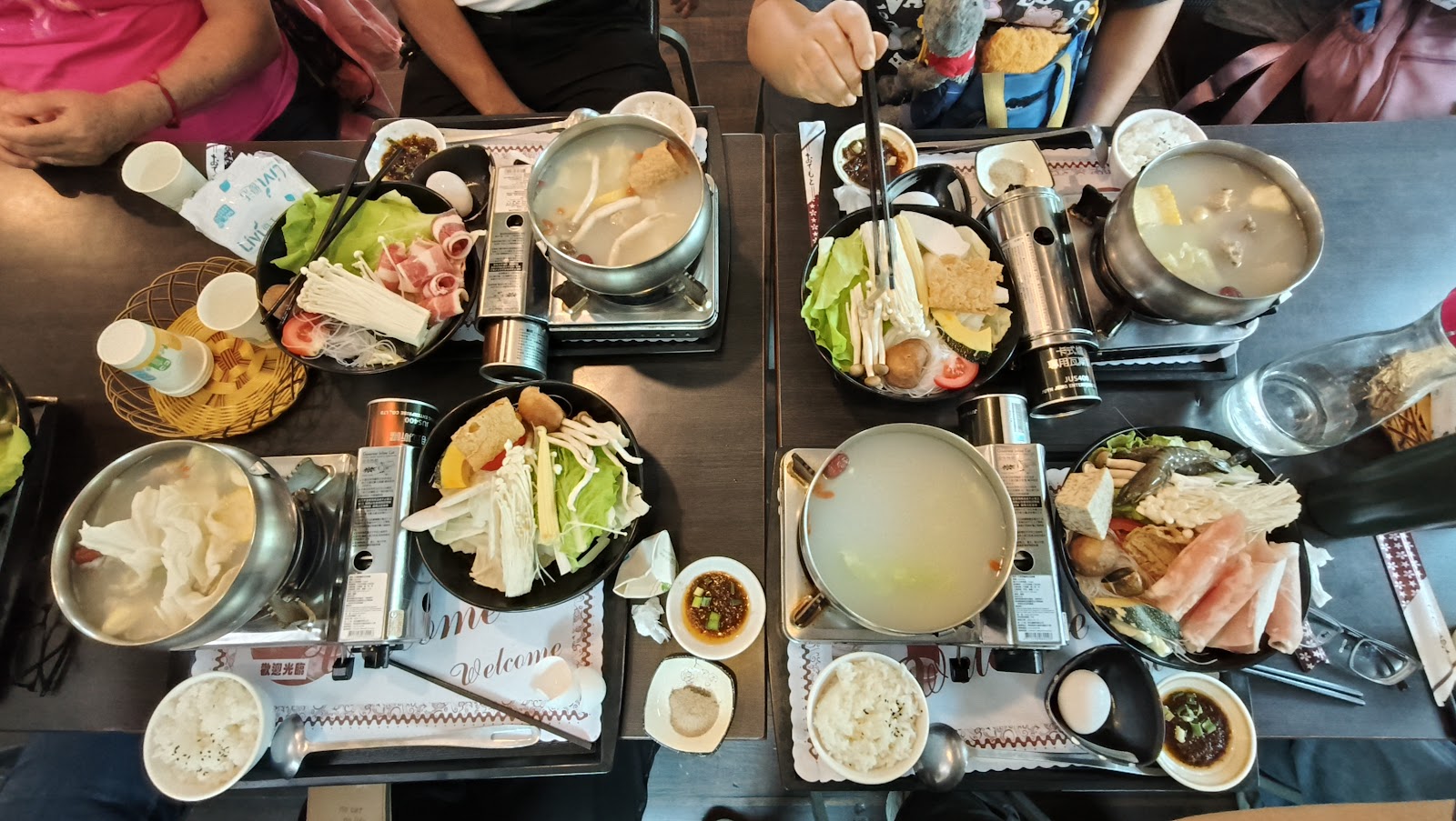新月傳說多人圍桌火鍋俯視，每人各有個人小火鍋，食材豐富多樣