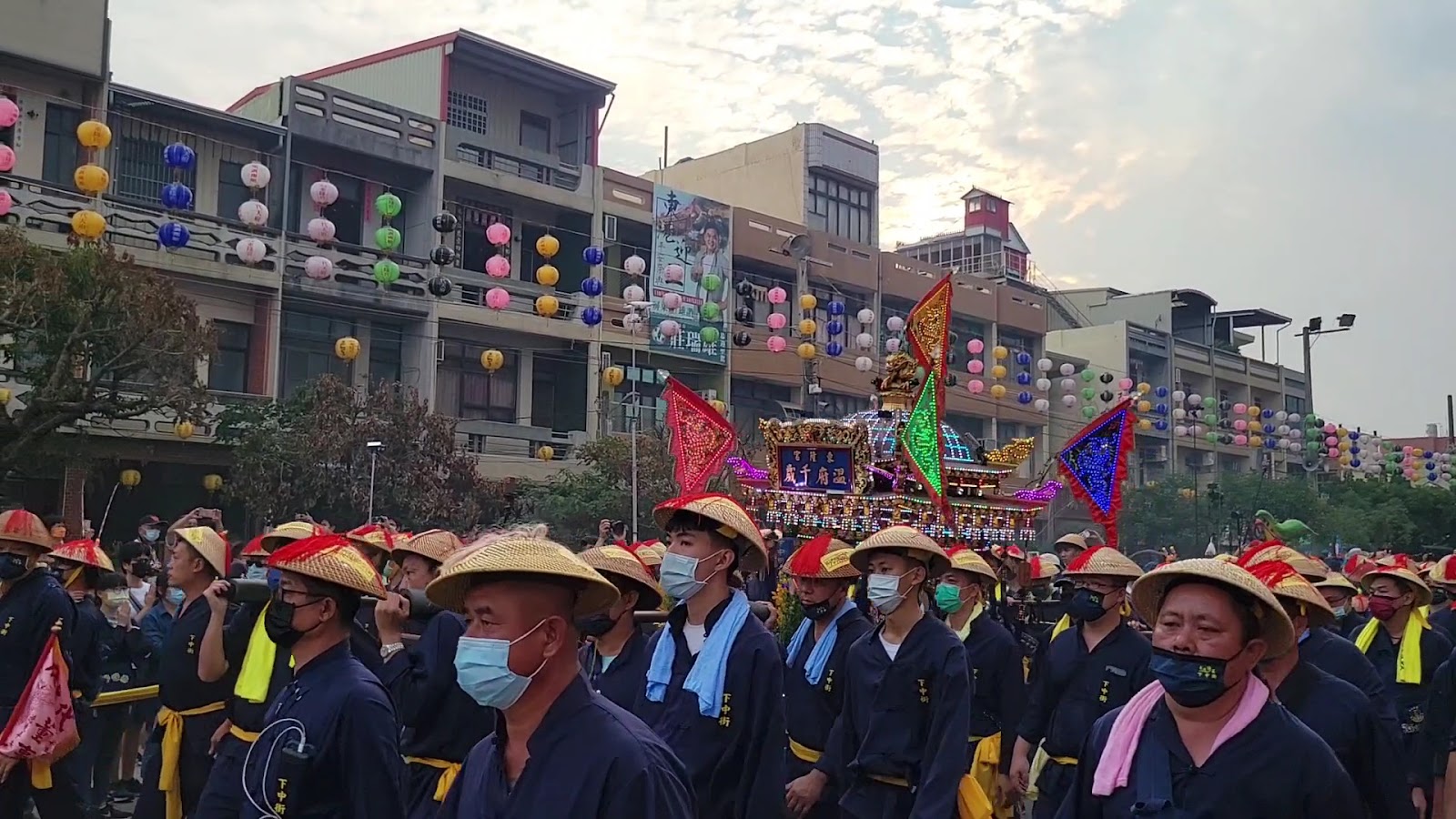 東港迎王祭典遊行隊伍，信眾戴竹笠帽列隊遶境，彩燈神轎