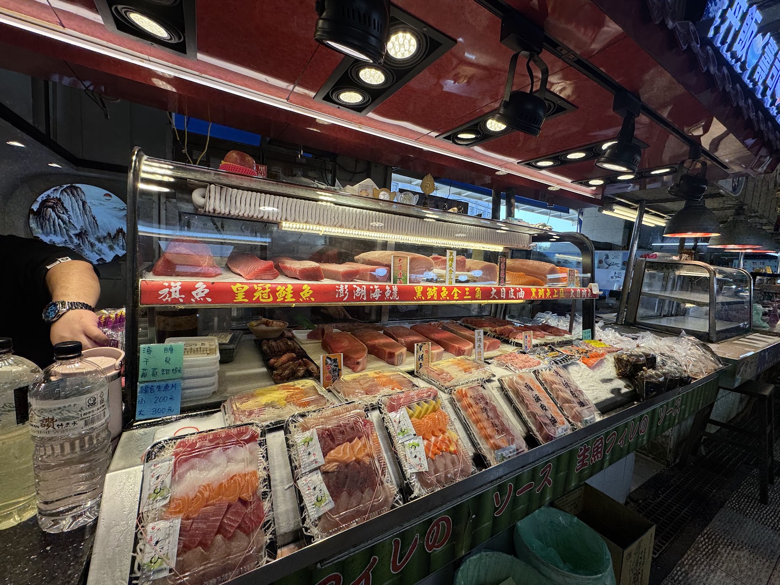 東港華僑市場生魚片攤，冷藏展示櫃擺滿各式生魚片，黑鮪魚旗魚鮭魚