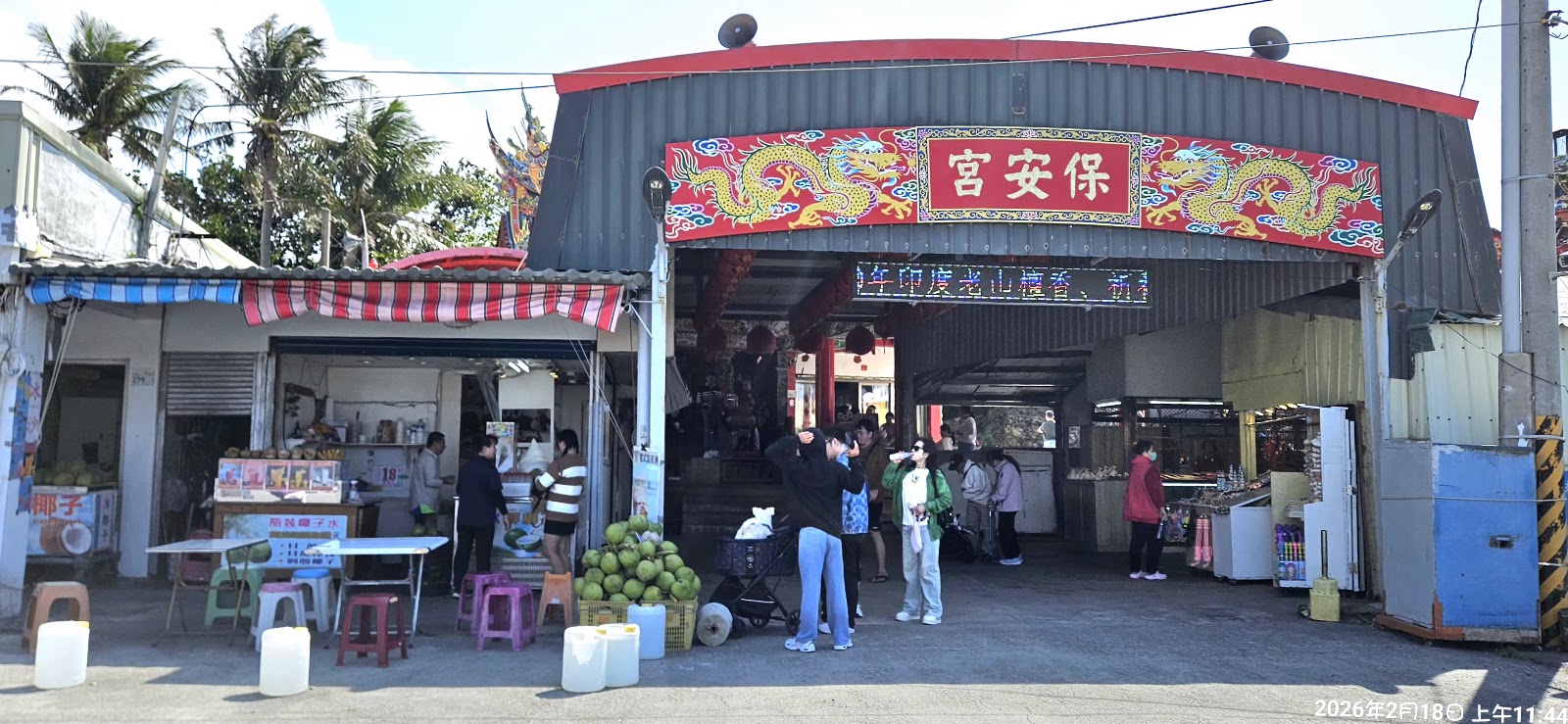 鵝鑾鼻保安宮廟宇入口,紅色飛龍裝飾,廟前椰子攤與觀光人潮