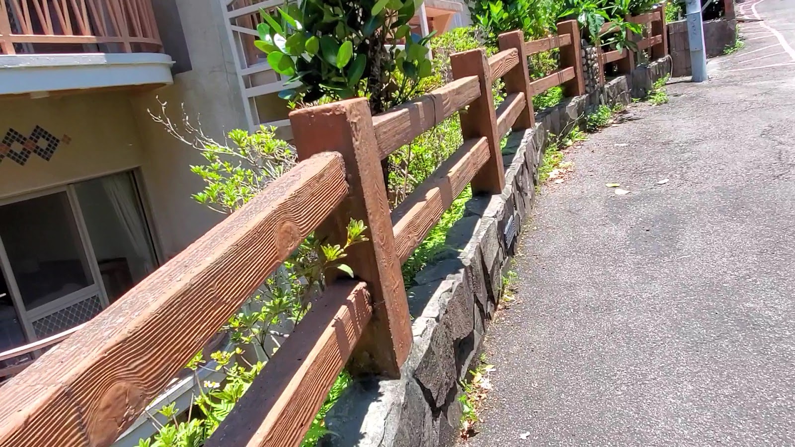 谷關溫泉飯店戶外走道，木欄杆，陽光照耀，綠植點綴