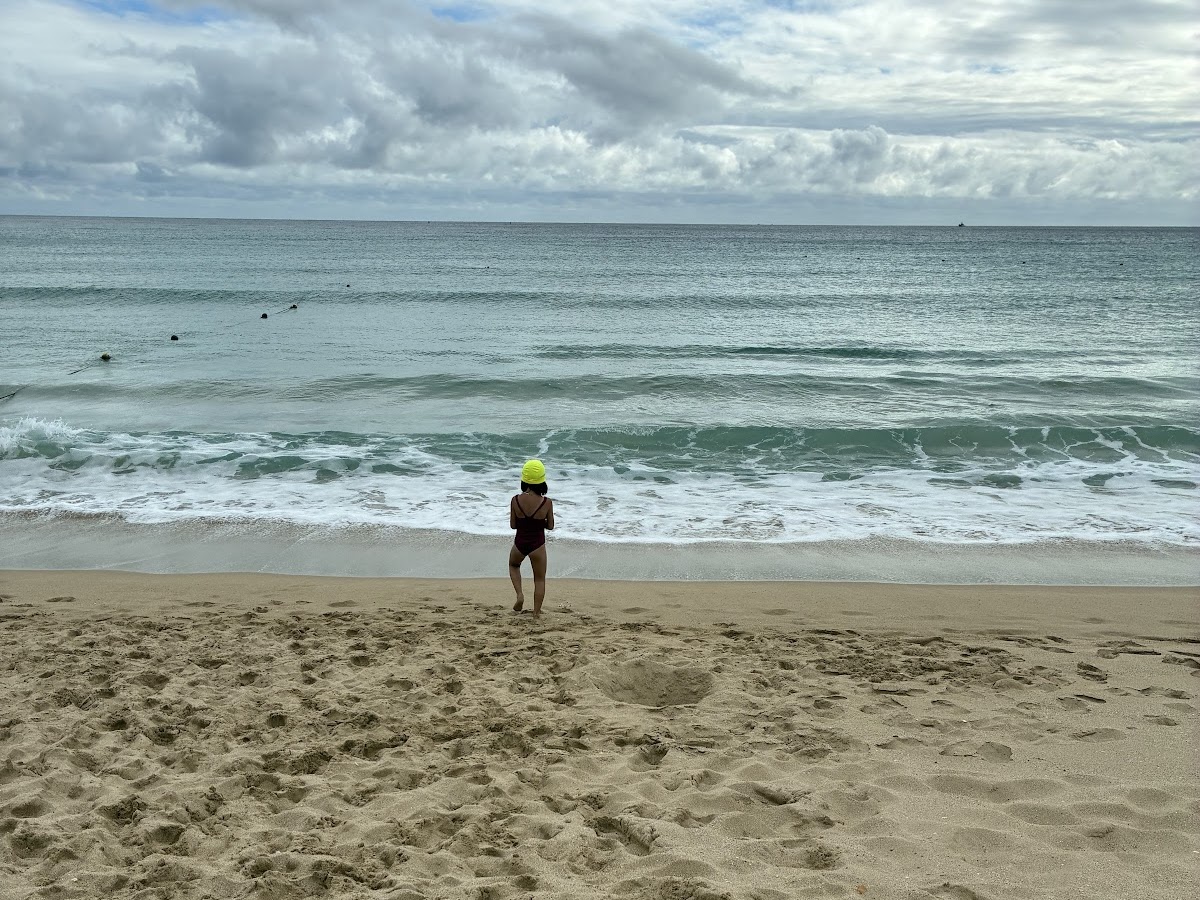 南灣海灘遊客站在海浪邊，背景是碧藍寬闊的大海