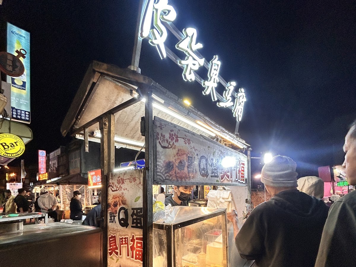 恆春夜市臭門福攤位霓虹招牌，人潮聚集排隊