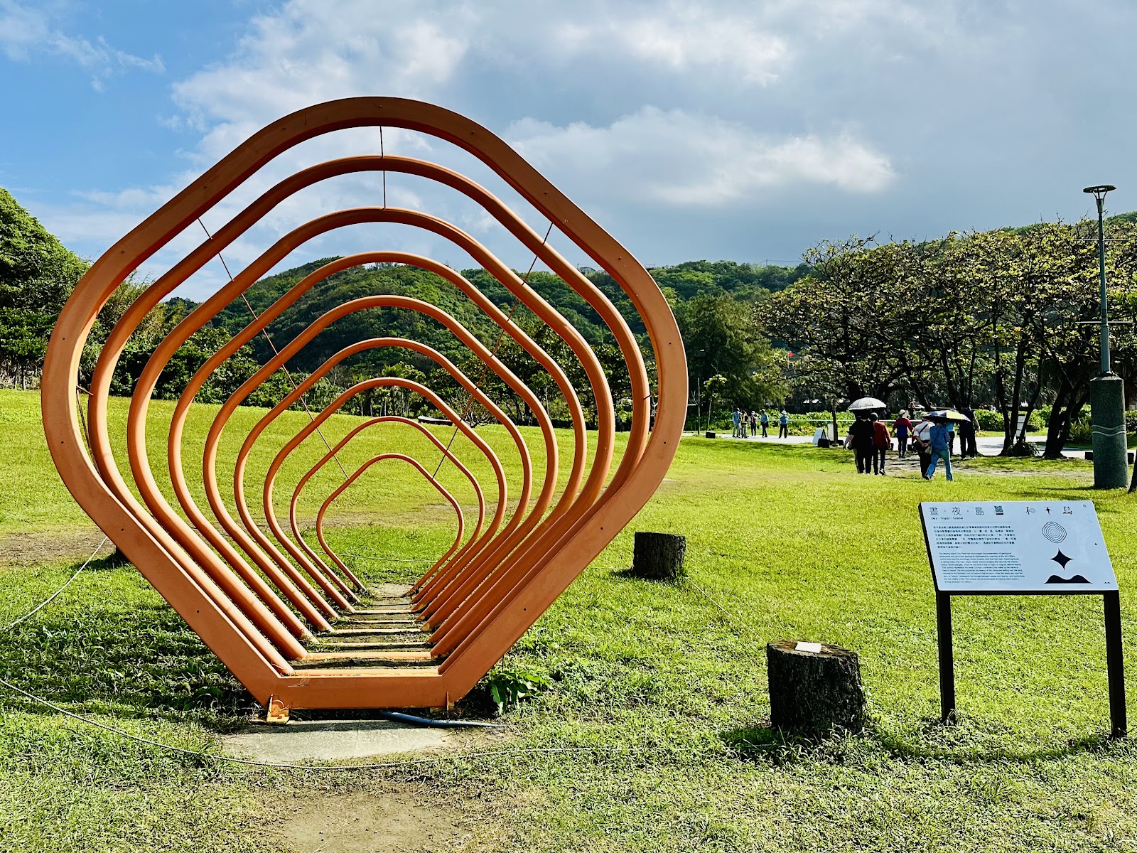 和平島星光草原橘色多層框架裝置藝術,背景藍天白雲與翠綠草地