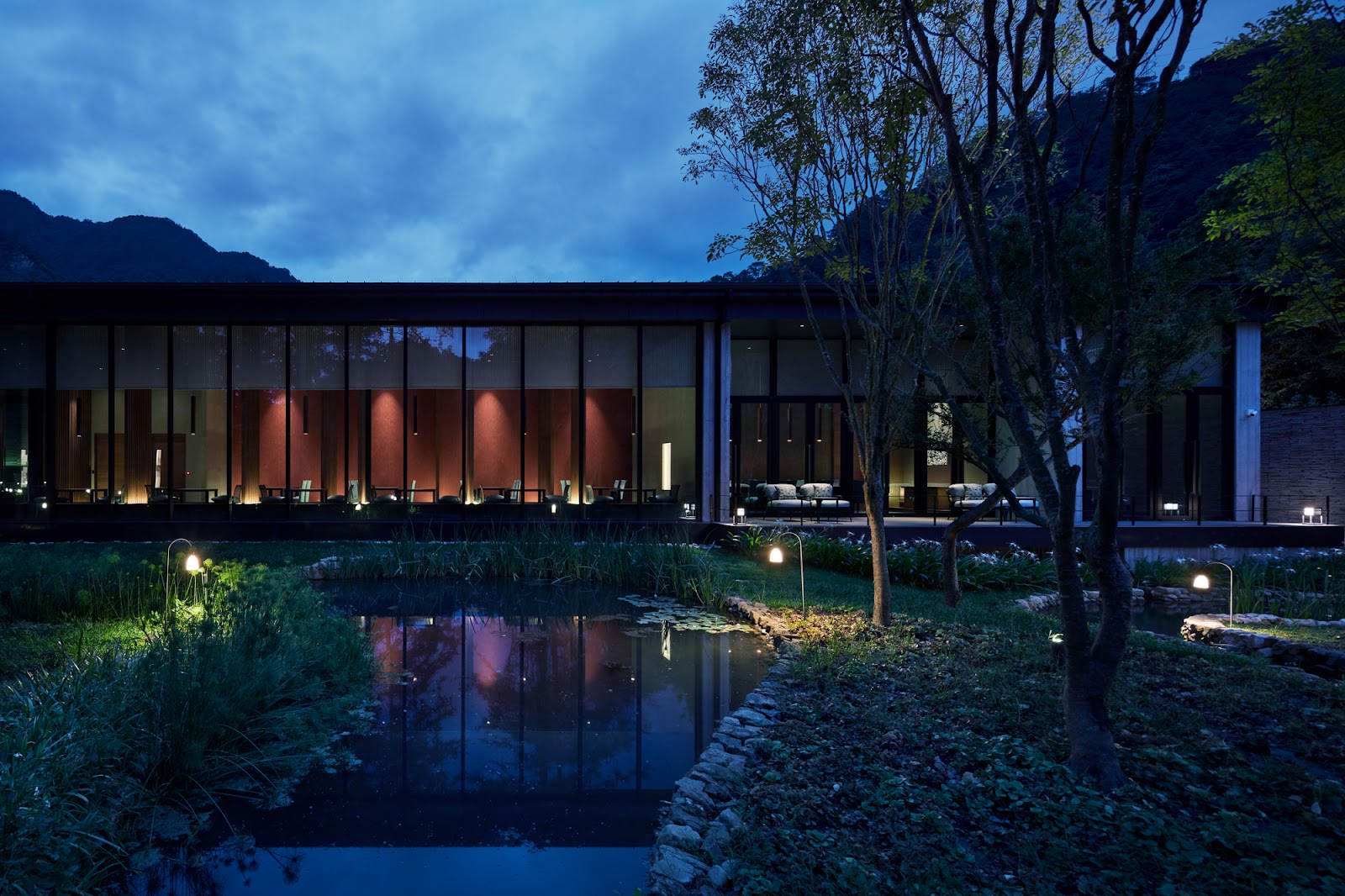 虹夕諾雅谷關夜間建築外觀，日式庭園水池倒映橘紅燈光，台中谷關溫泉推薦