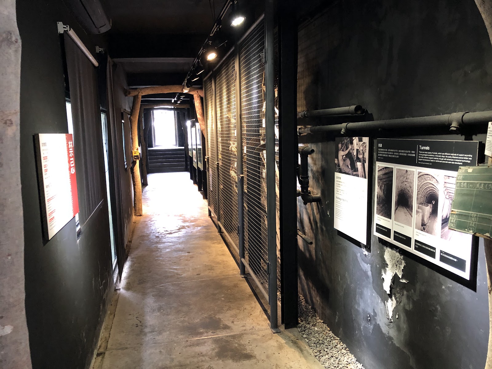 猴硐坑展館礦坑走廊內部，黑色牆面與歷史展覽說明板