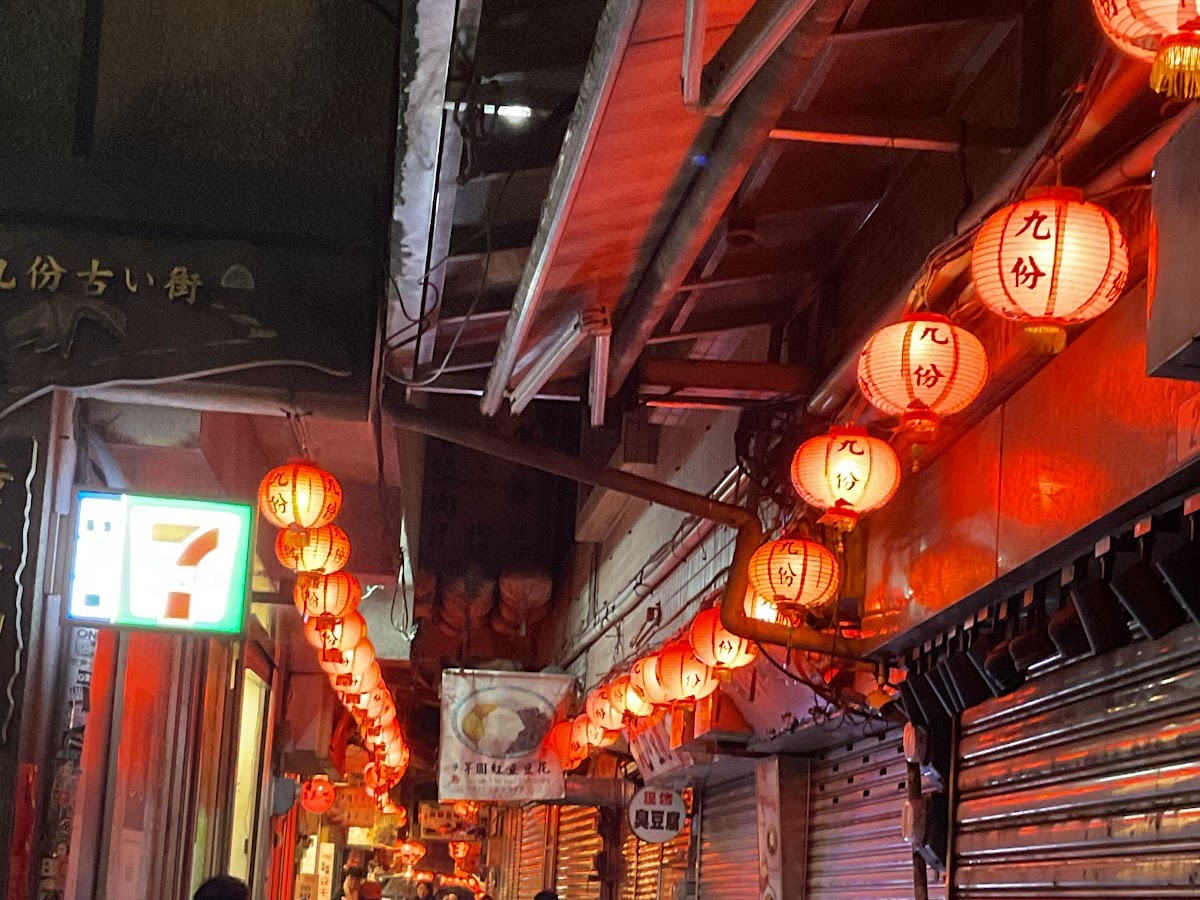 九份老街入夜後紅燈籠全亮，九份字樣燈籠懸掛屋簷下