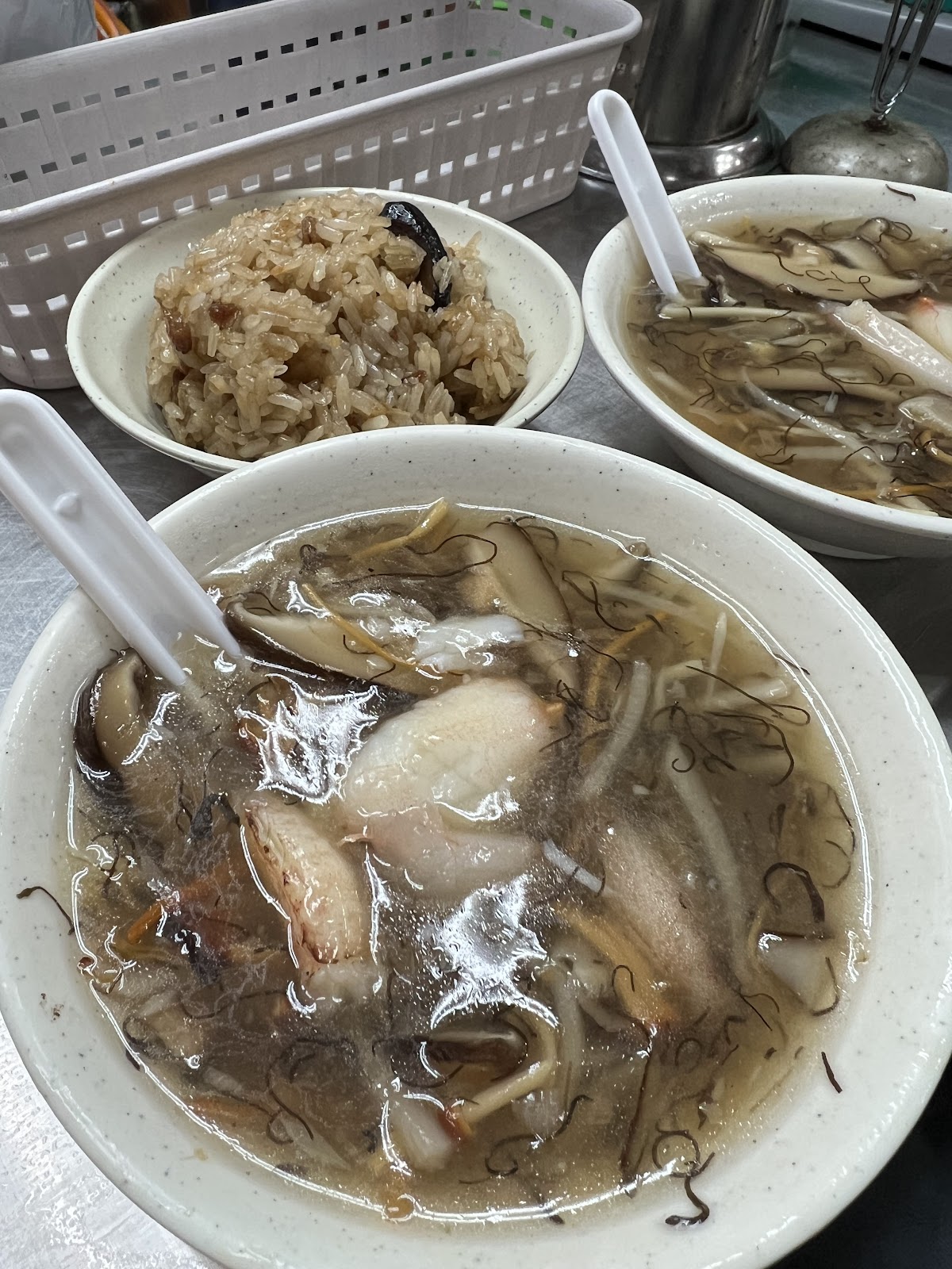 廟口夜市蚵仔湯近照，白碗盛有肥美蚵仔和魚丸，清湯底