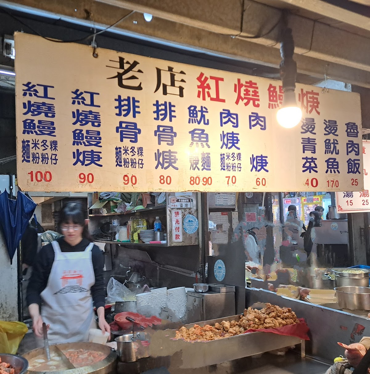 廟口夜市老店紅燒鰻燒攤位白色大型菜單，列出多種品項及價格