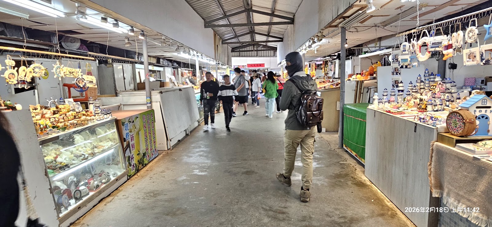 墾丁夜市室內市集走廊,兩側攤位掛滿海洋風紀念品和各式小吃