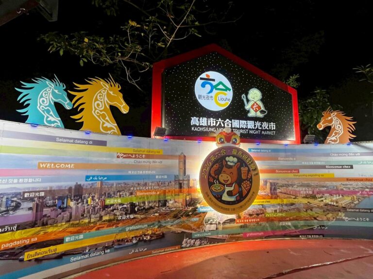 高雄市六合國際觀光夜市入口牌樓夜景，多國語言歡迎標語