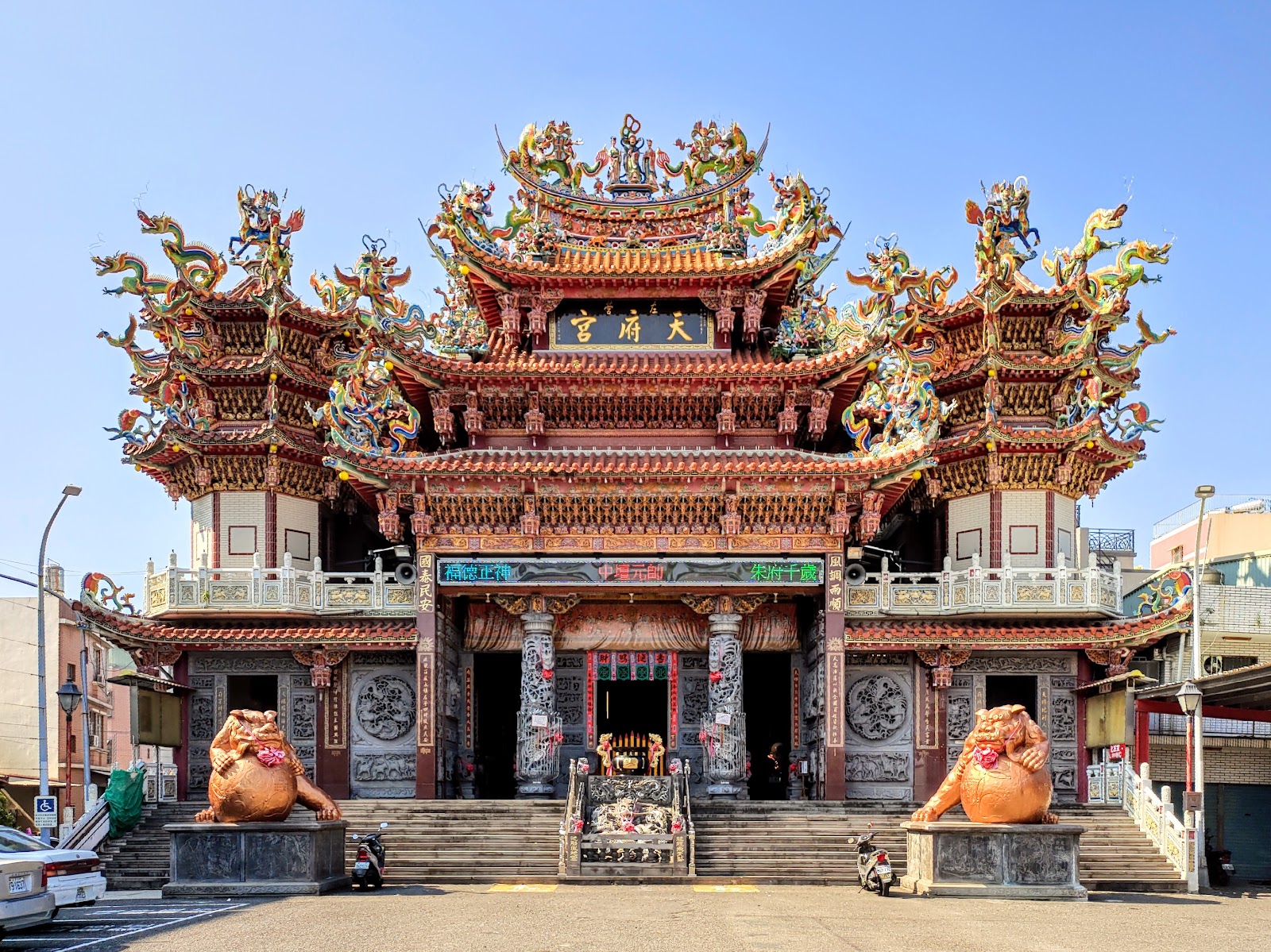 左營天府宮廟正面全景，匾額天府宮，橘紅石獅一對，屋頂精雕龍鳳