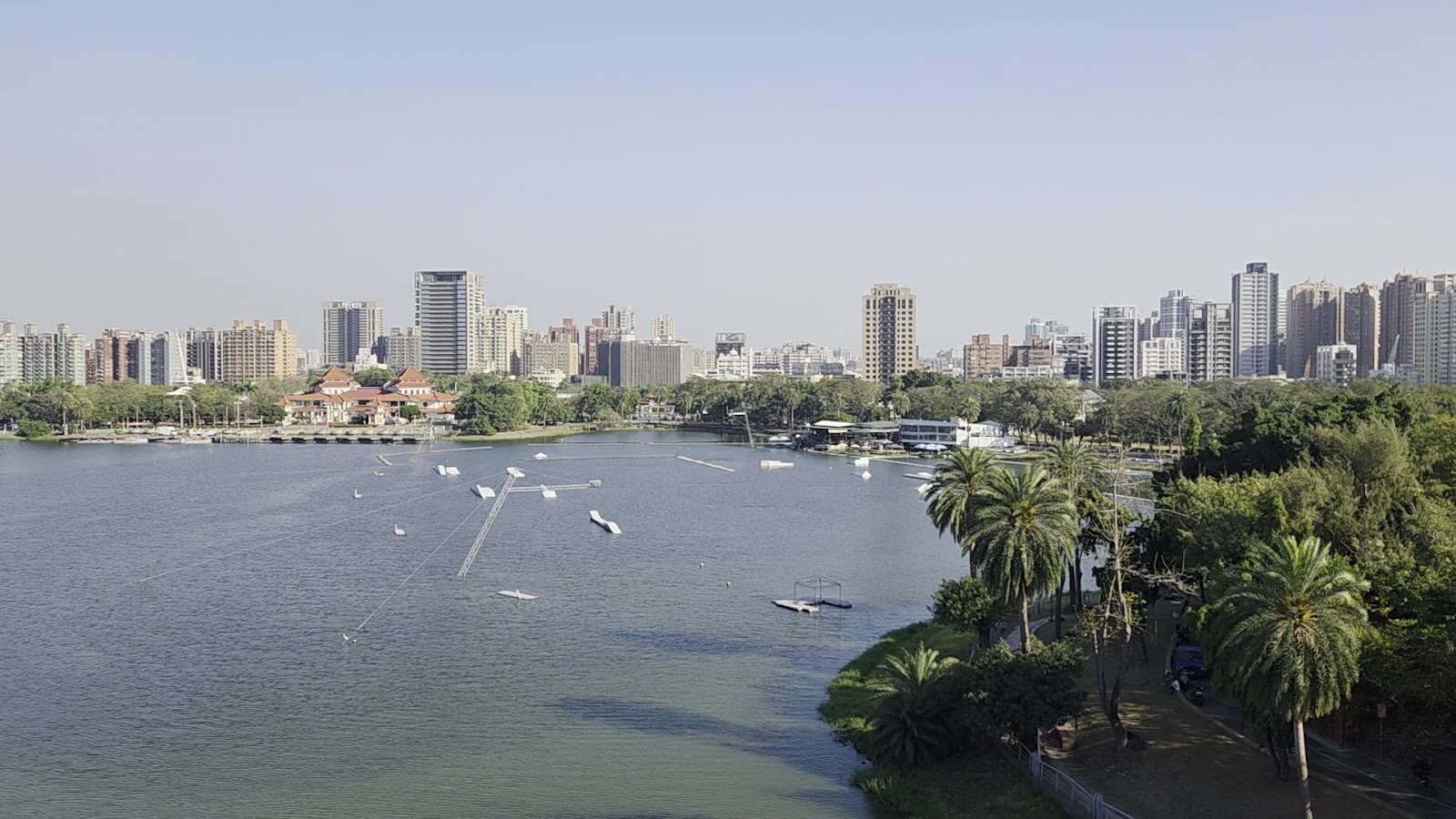 蓮池潭湖面全景，遠眺左營市區高樓與棕梠樹