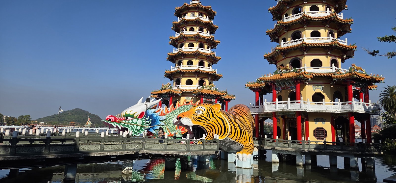 龍虎塔日間全景，黃色寶塔配藍天，龍虎立於水上