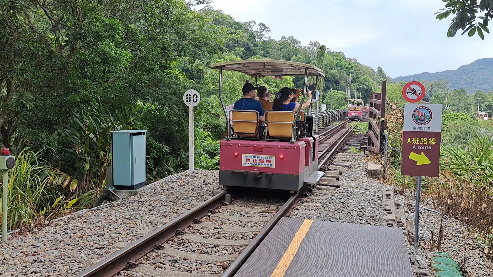 台鐵舊山線電動台車鐵道自行車體驗，遊客乘坐紅色台車在鐵道上行駛