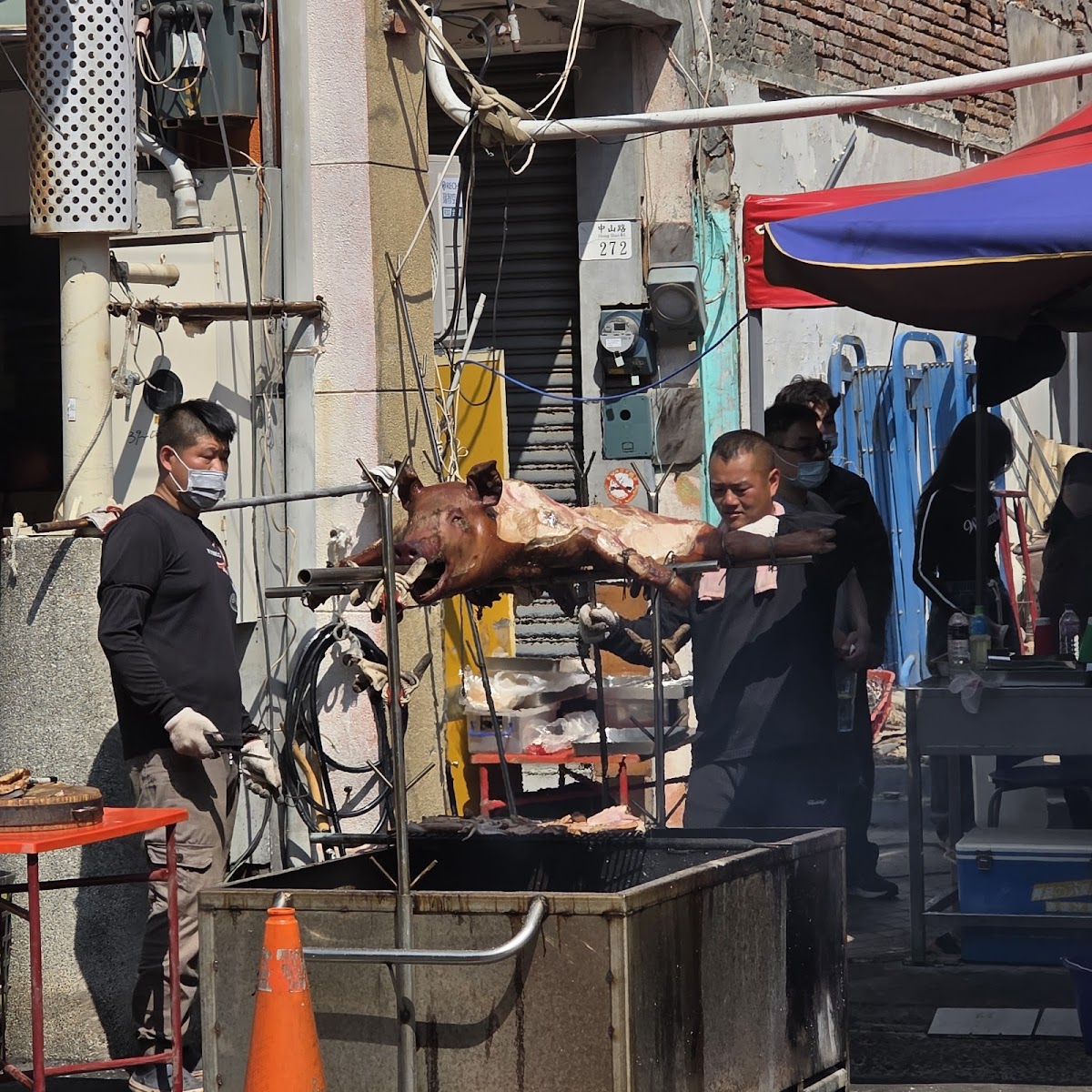 鹿港老街廟會場景，師傅翻轉烤全豬