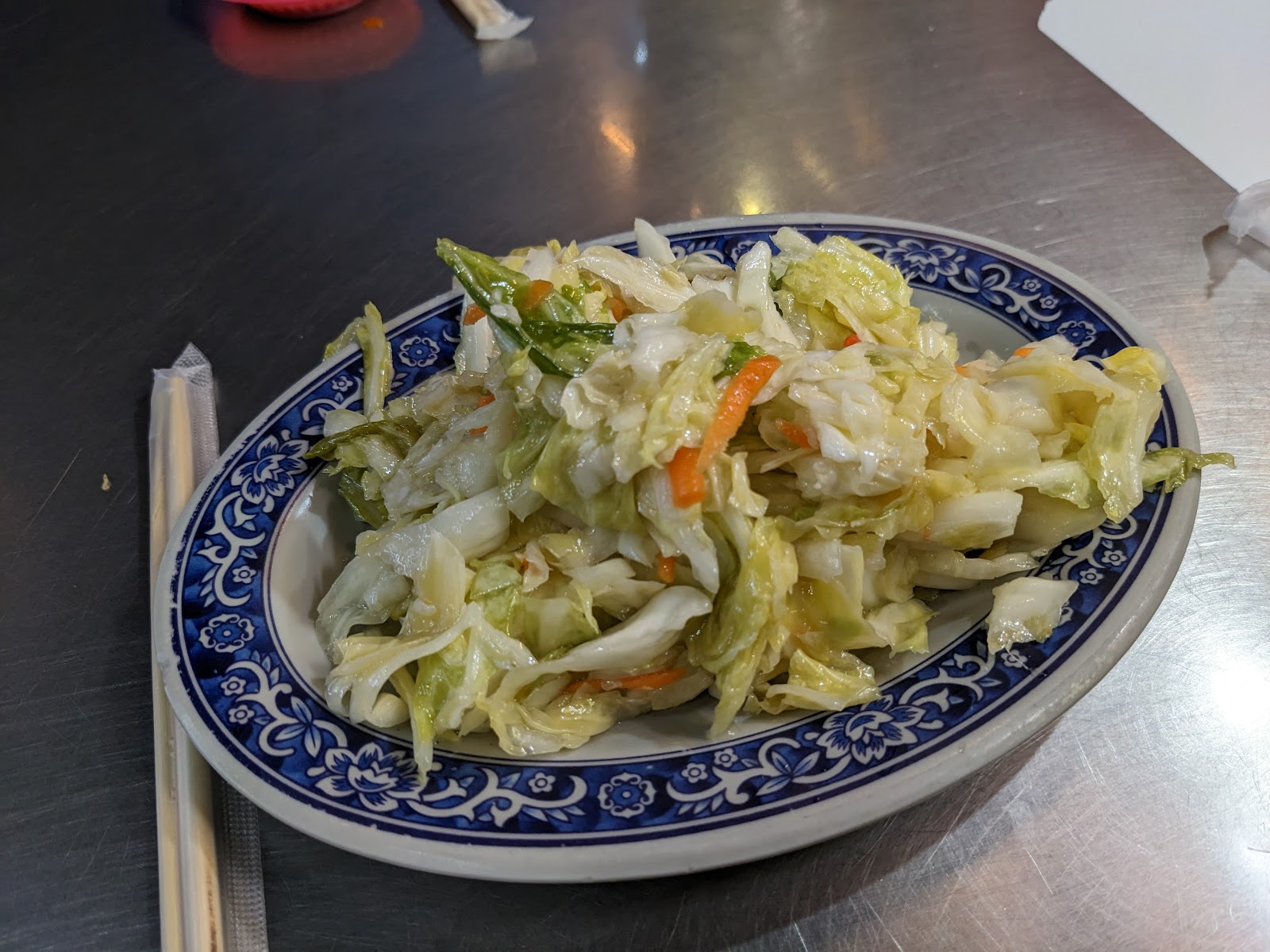 清炒高麗菜加胡蘿蔔，藍白瓷盤，搭配羊肉料理的清爽小菜