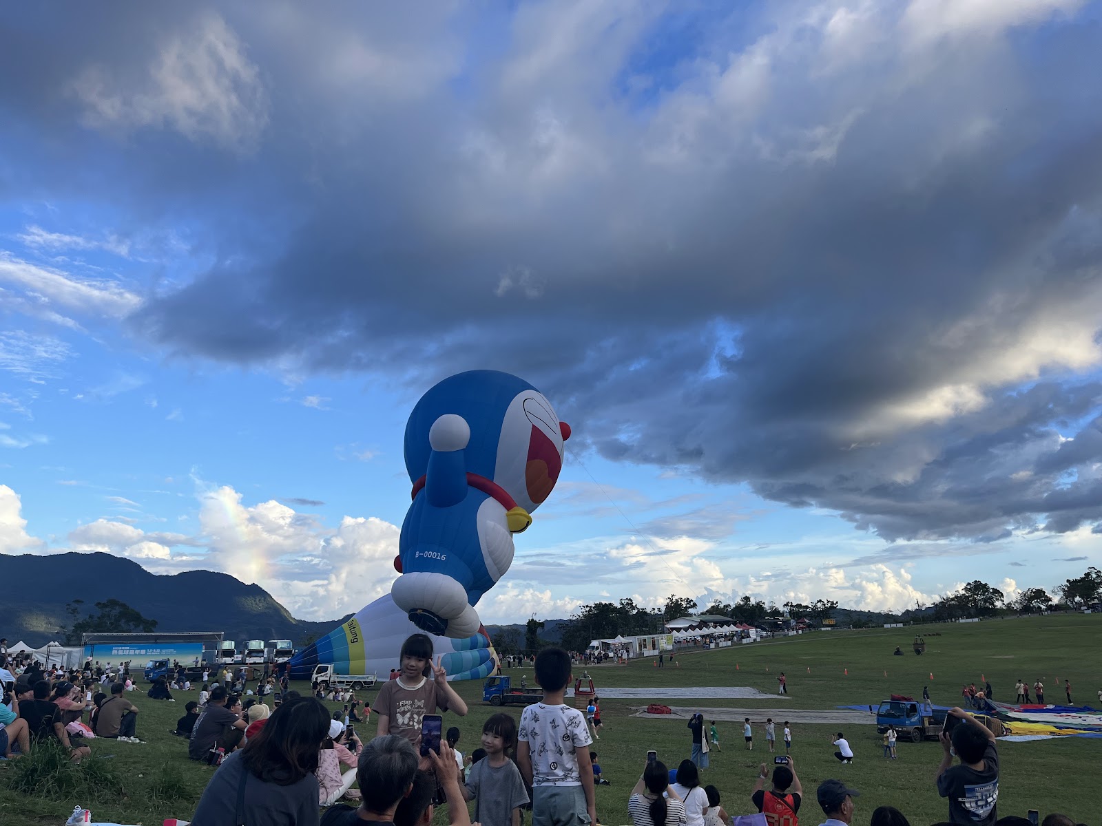 哆啦A夢熱氣球側面近拍升空，周圍人群拍照
