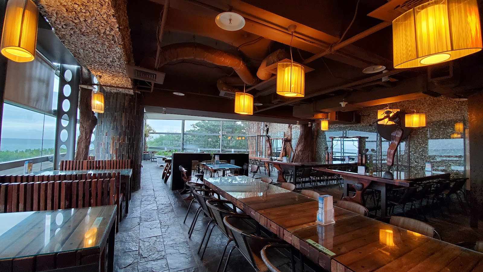 海生館海景餐廳 木質桌椅暖燈 石砌礁石牆面