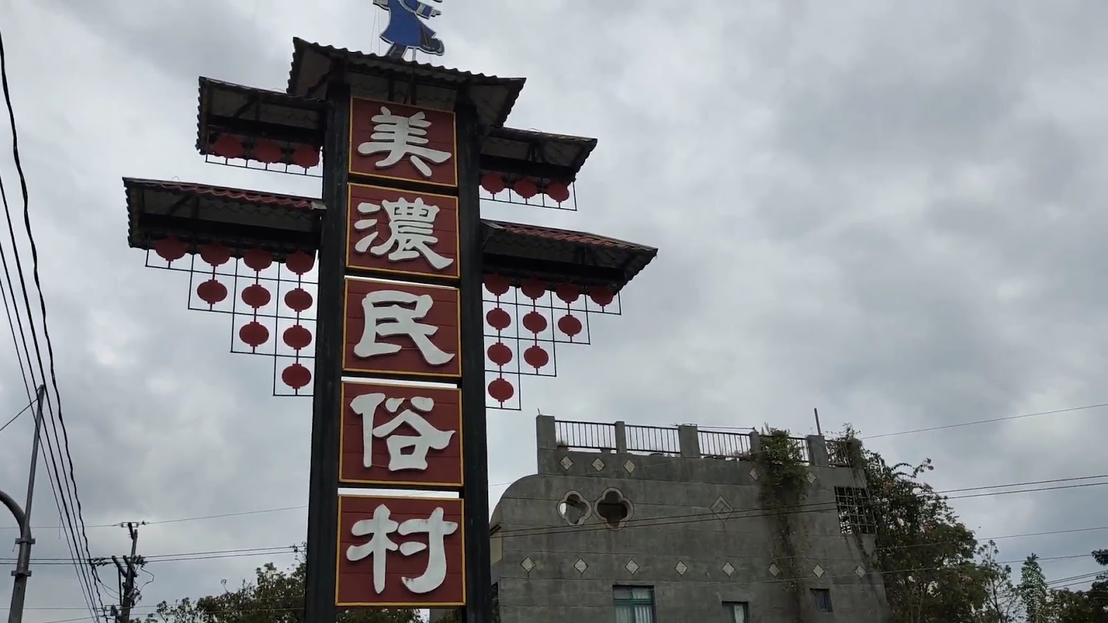 美濃民俗村入口招牌高塔，紅底白字加紅燈籠