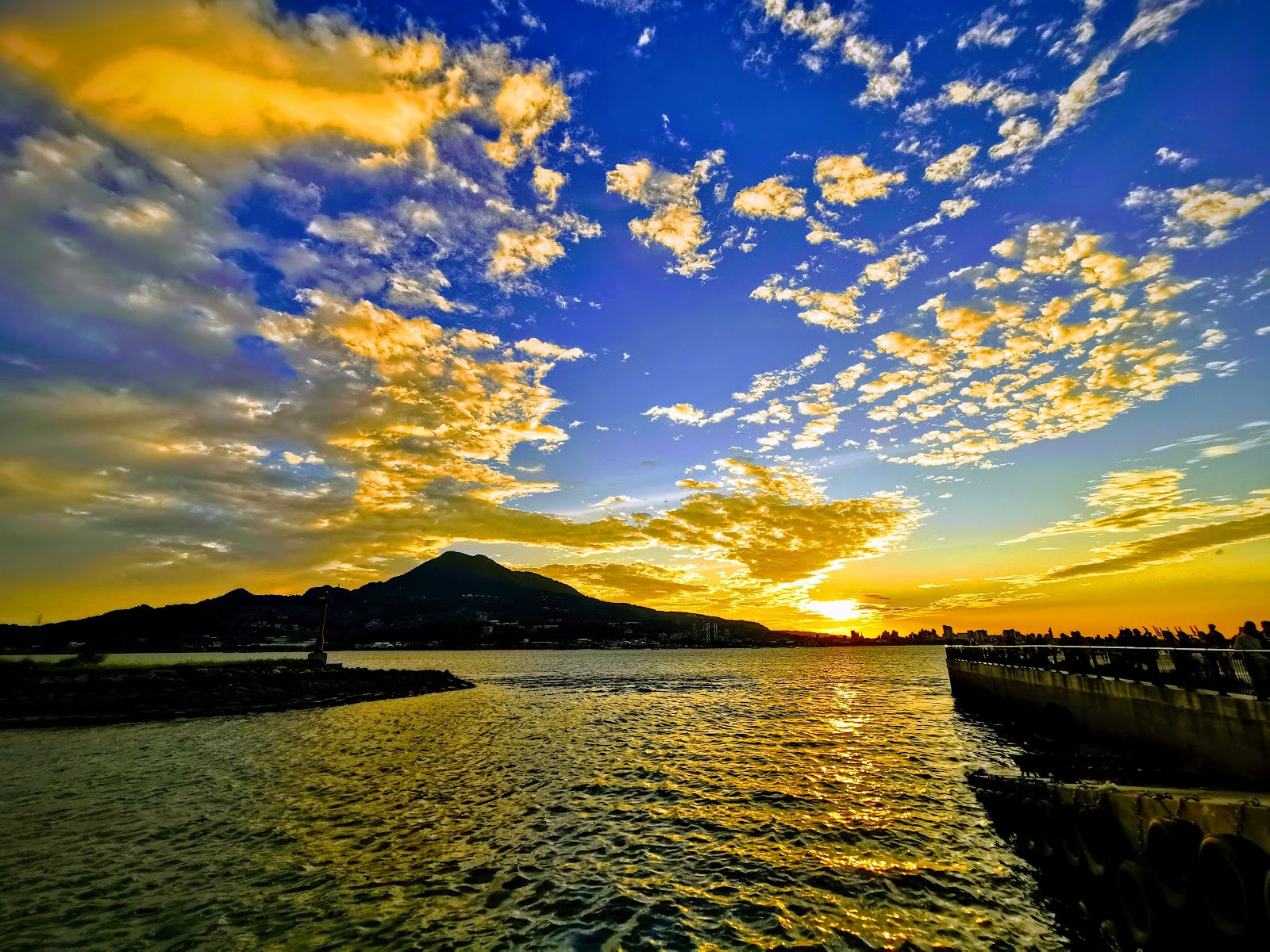 淡水金色水岸橙金夕陽映照淡水河面，傍晚最美河景步道