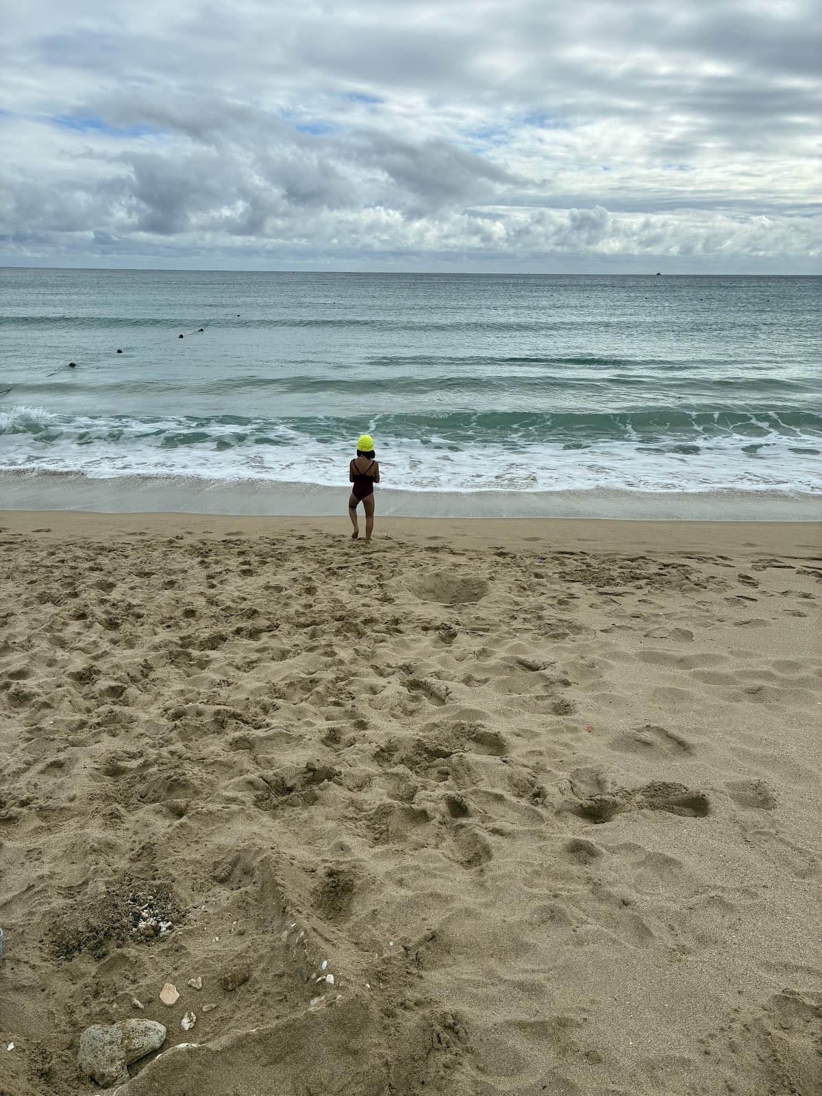 南灣遊憩區沙灘,遊客站在水邊望向翠藍海浪