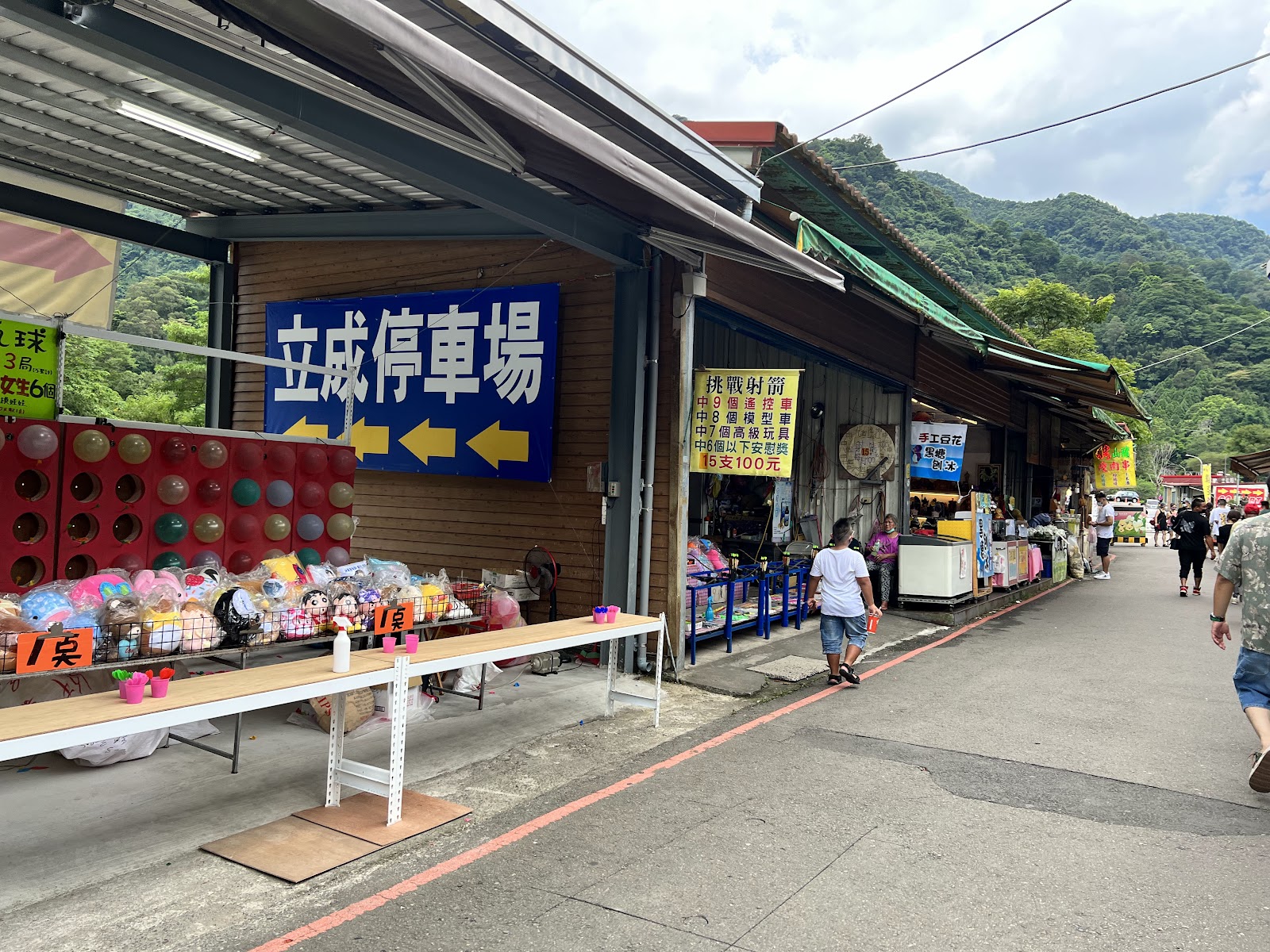 內灣老街市集攤位走廊，遊客逛攤，山景背景，新竹一日遊景點
