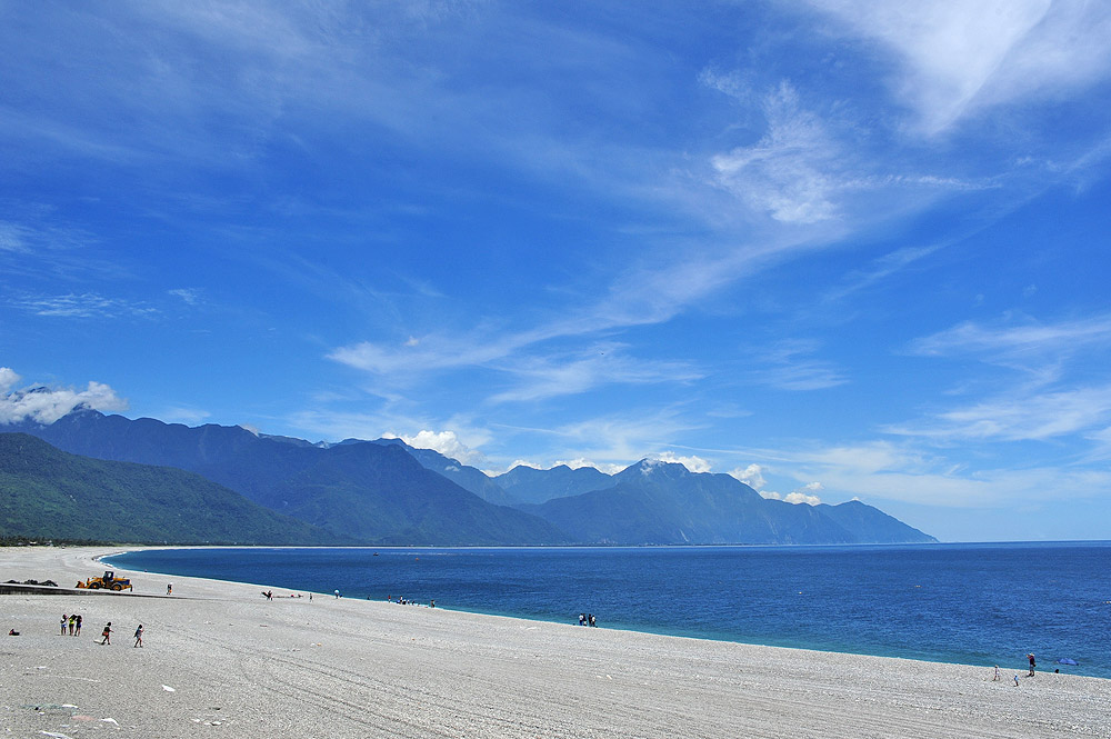 花蓮七星潭月牙灣礫石海灘全景，背景青山翠嶺