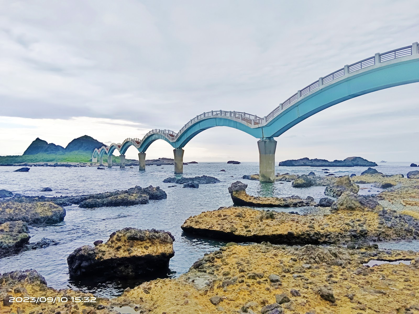 三仙台八拱跨海步橋近景特寫，藍色橋拱搭配礁岩海景與三仙台島嶼