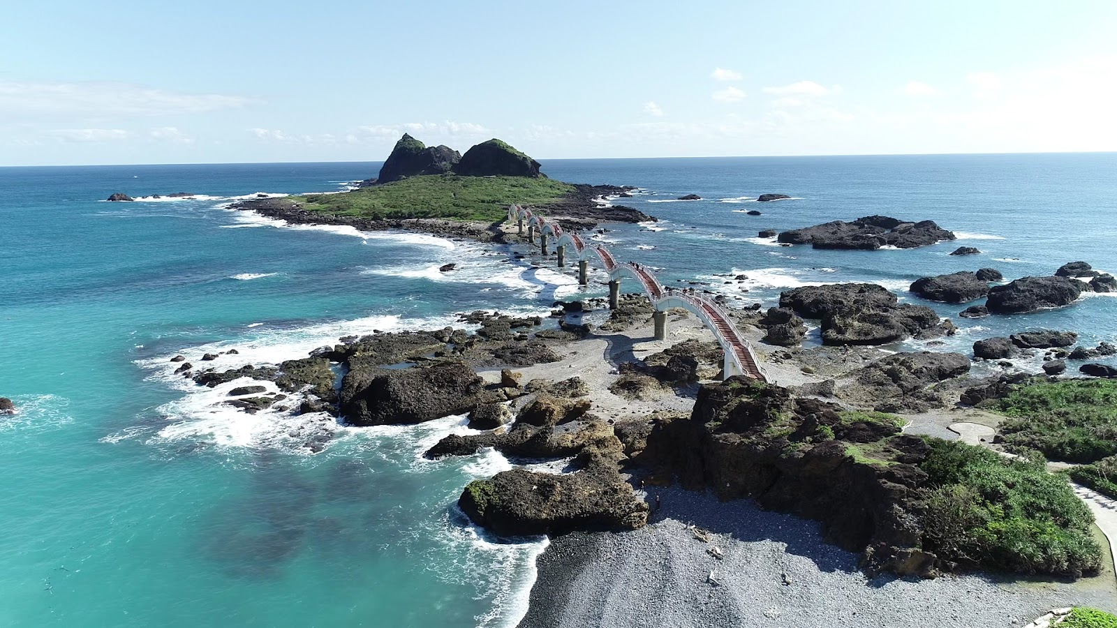 台東三仙台空拍全景，八拱跨海步橋蜿蜒連接三仙台島嶼，四周蔚藍太平洋