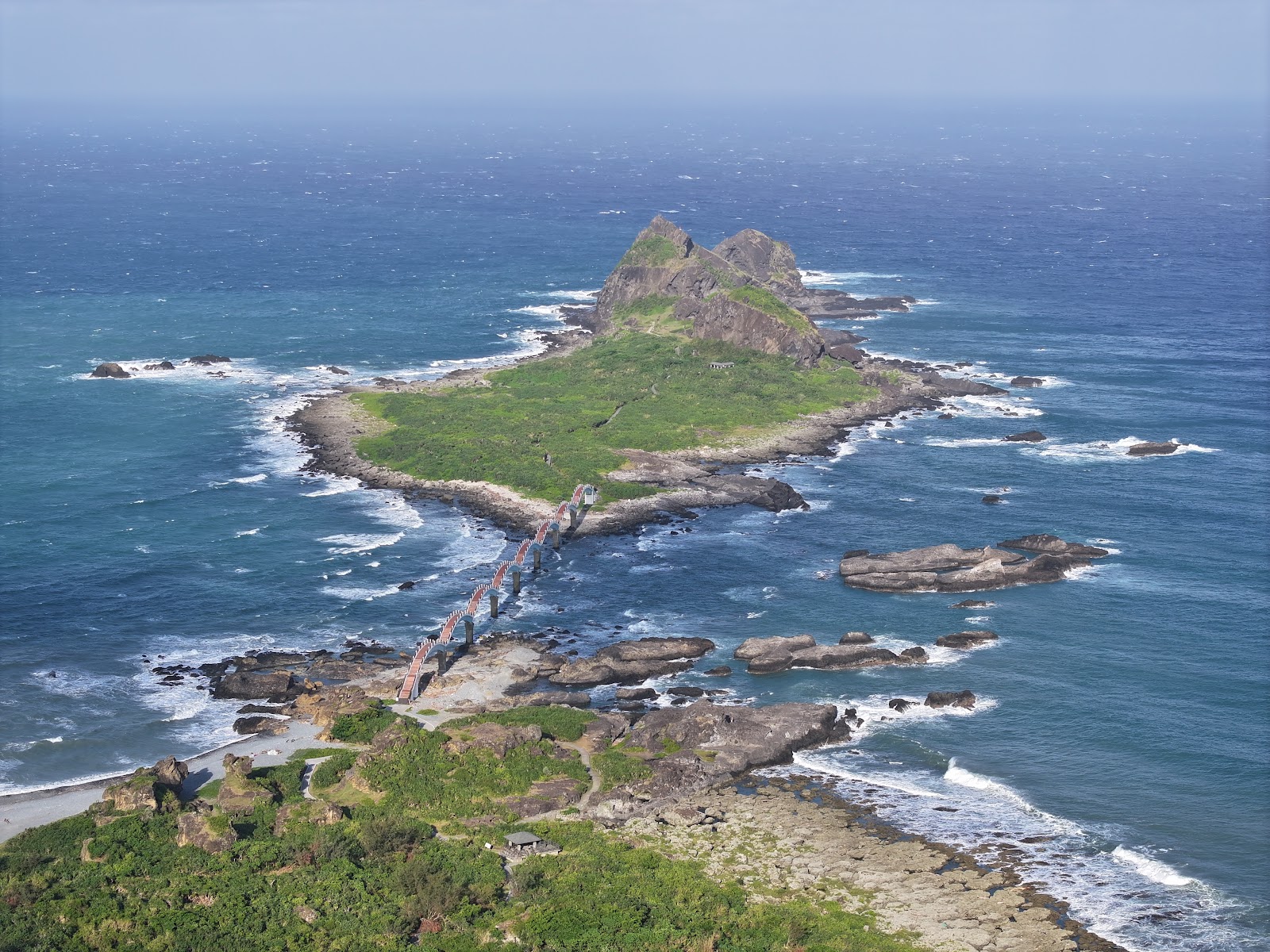 高空俯瞰三仙台島嶼全貌，綠色植被覆蓋，礁石散布四周，太平洋包圍