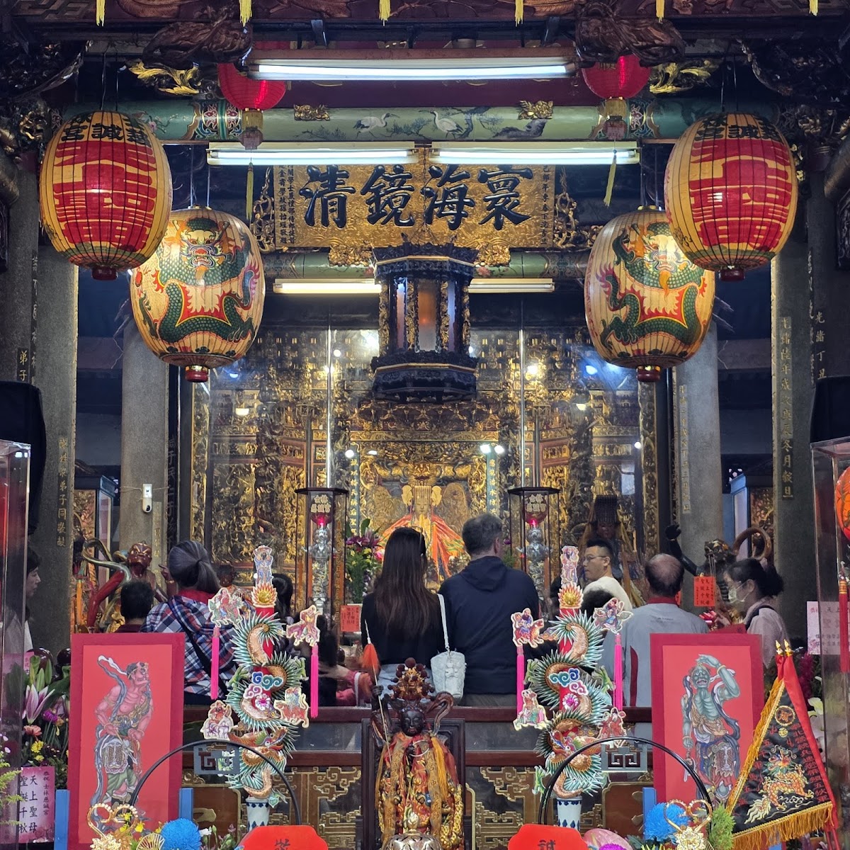 士林慈誠宮廟內主殿,金色神龕彩色燈籠,信眾參拜