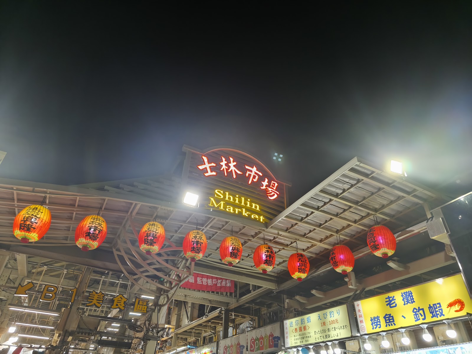 仰拍士林市場招牌夜景,美食區指示牌清晰可見
